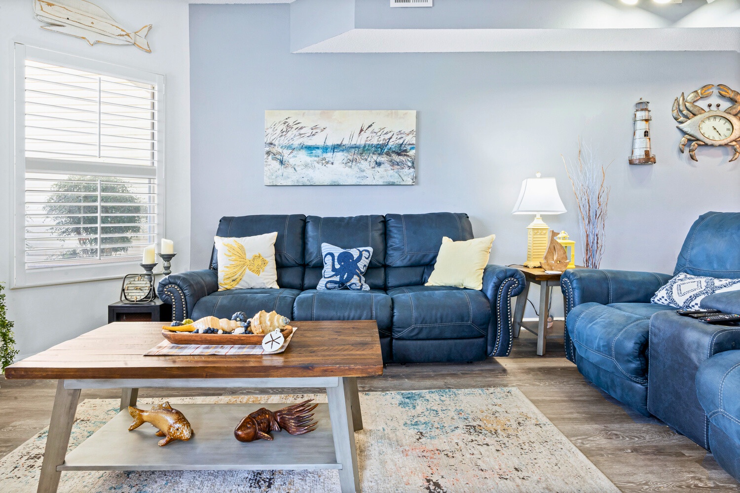 Sink into the coastal-themed living room where plush navy sofas and nautical décor create your perfect seaside retreat.