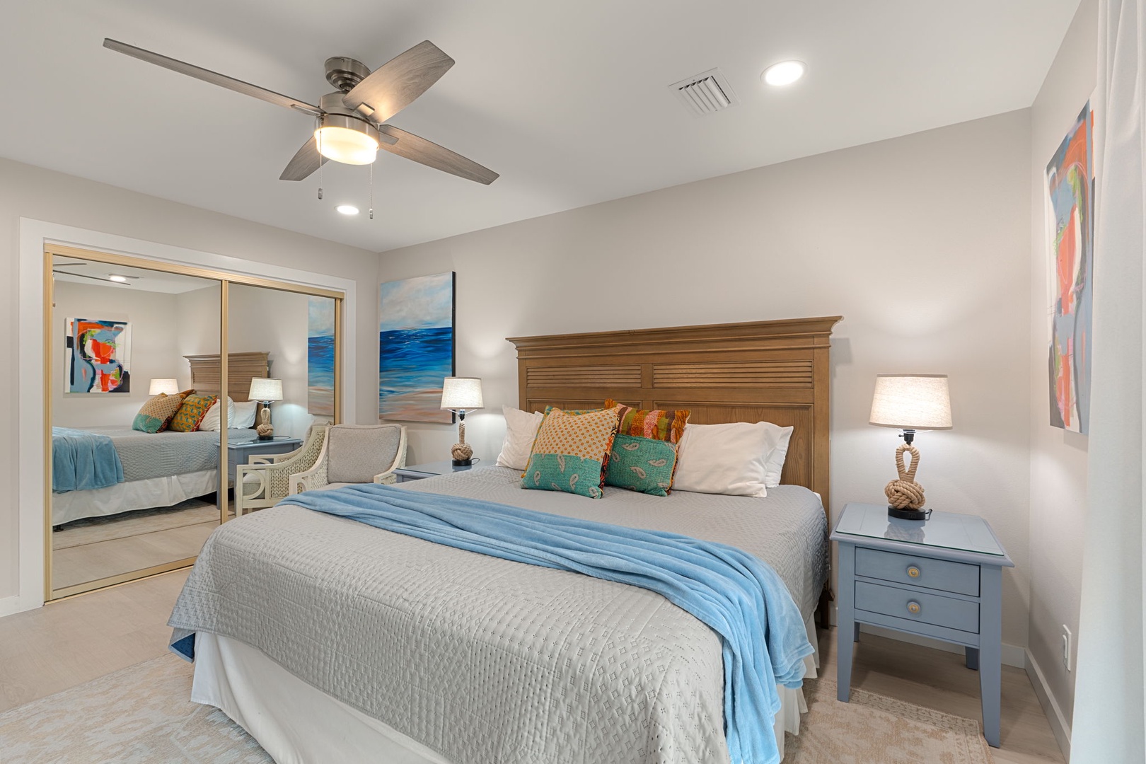 Your coastal-inspired bedroom offers peaceful comfort with soft linens, ocean artwork, and gentle ceiling fan breezes for perfect sleep.