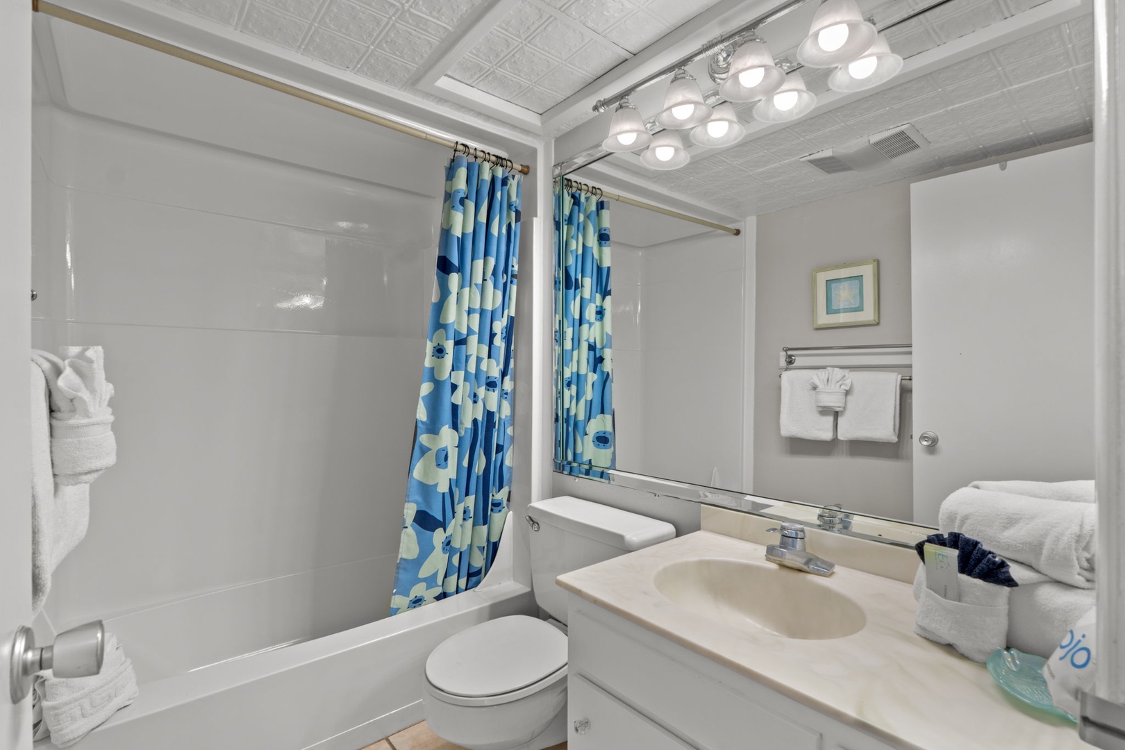 Your private bathroom features bright lighting, a tub-shower combo, and cheerful touches to refresh after beach adventures.