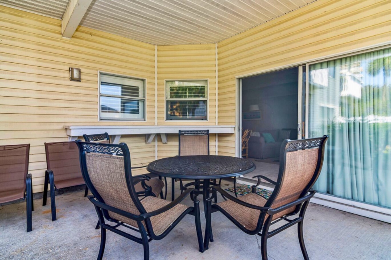 Your private covered patio offers comfortable outdoor dining with stylish furniture, perfect for morning coffee or evening meals.