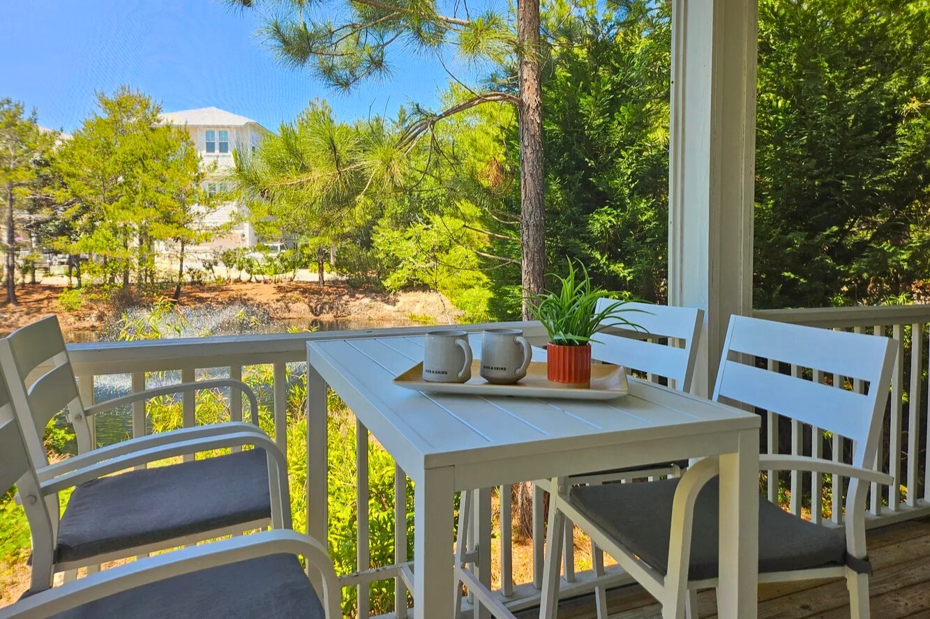Enjoy morning coffee and evening breezes on this peaceful screened porch. Surrounded by lush greenery, it’s the perfect spot to relax, dine, and unwind after a sun-soaked beach day.