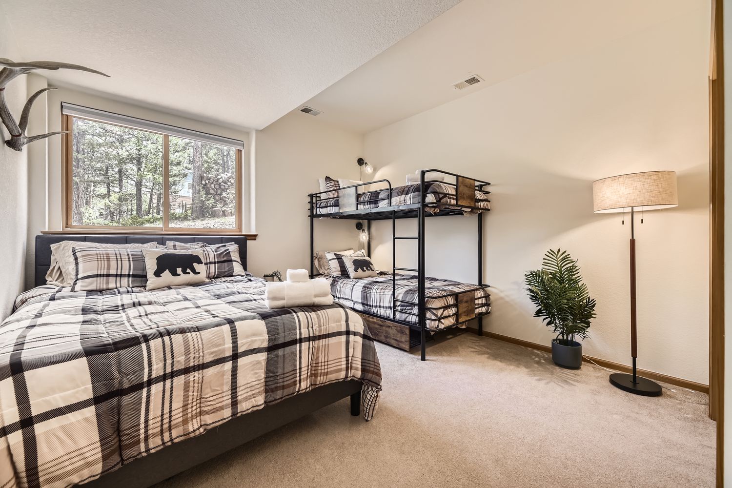 Your cozy bedroom features comfortable beds with rustic plaid bedding, perfect for families or groups traveling together.