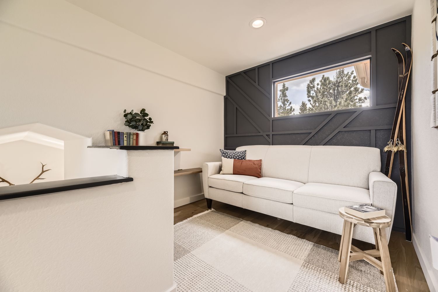 Curl up on this cozy white sofa with your favorite book, surrounded by modern minimalist design and natural light streaming through the window.