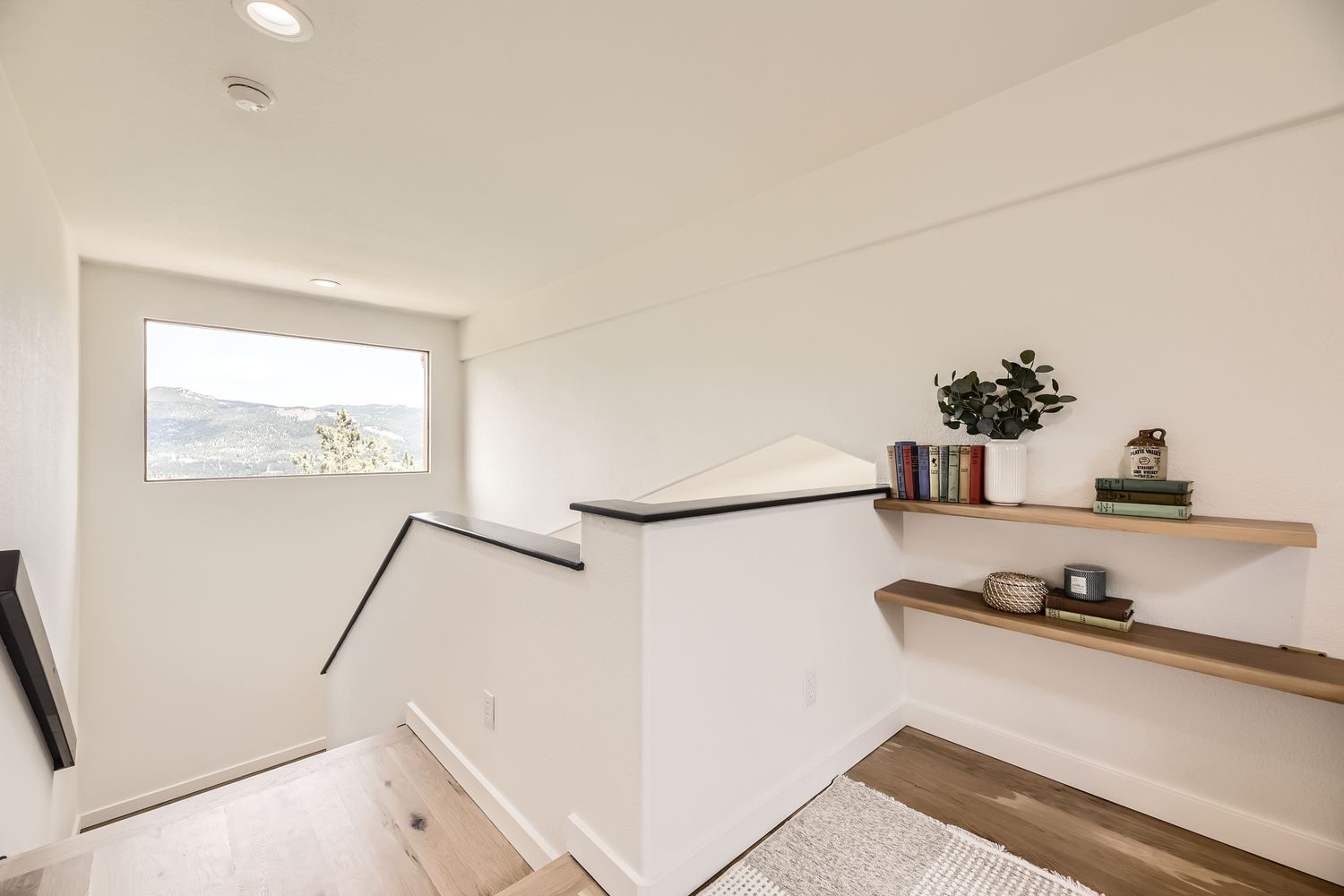 Your stylish stairway features floating shelves perfect for your books and thoughtful decor touches, with mountain views welcoming you home.