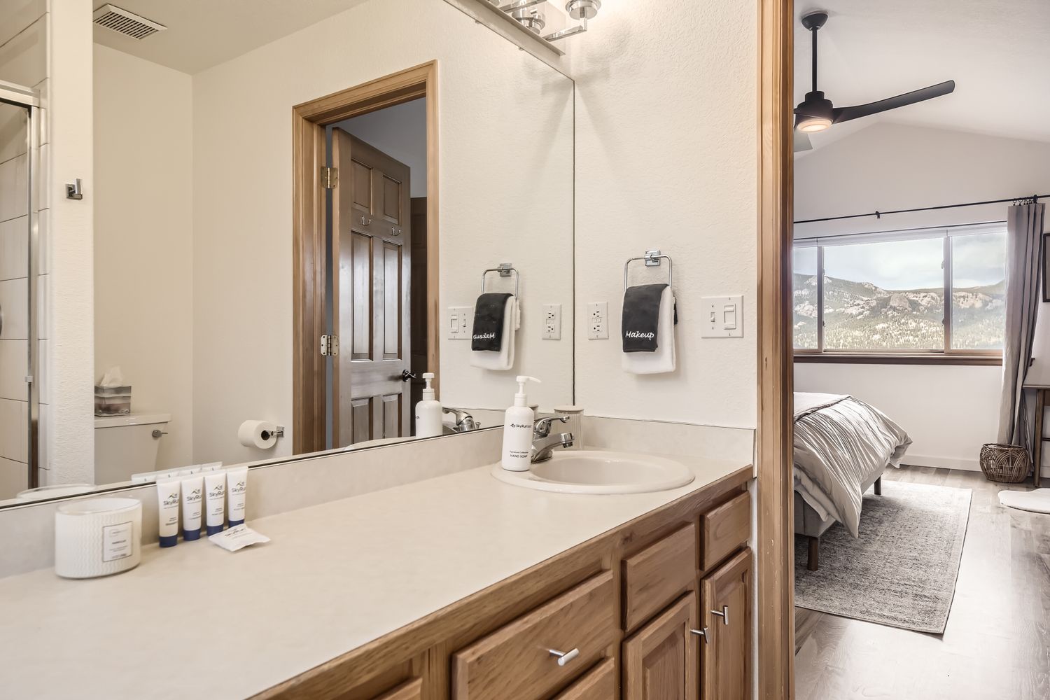 Your private bathroom features premium amenities and warm wood finishes, connecting seamlessly to your comfortable bedroom with stunning mountain views.