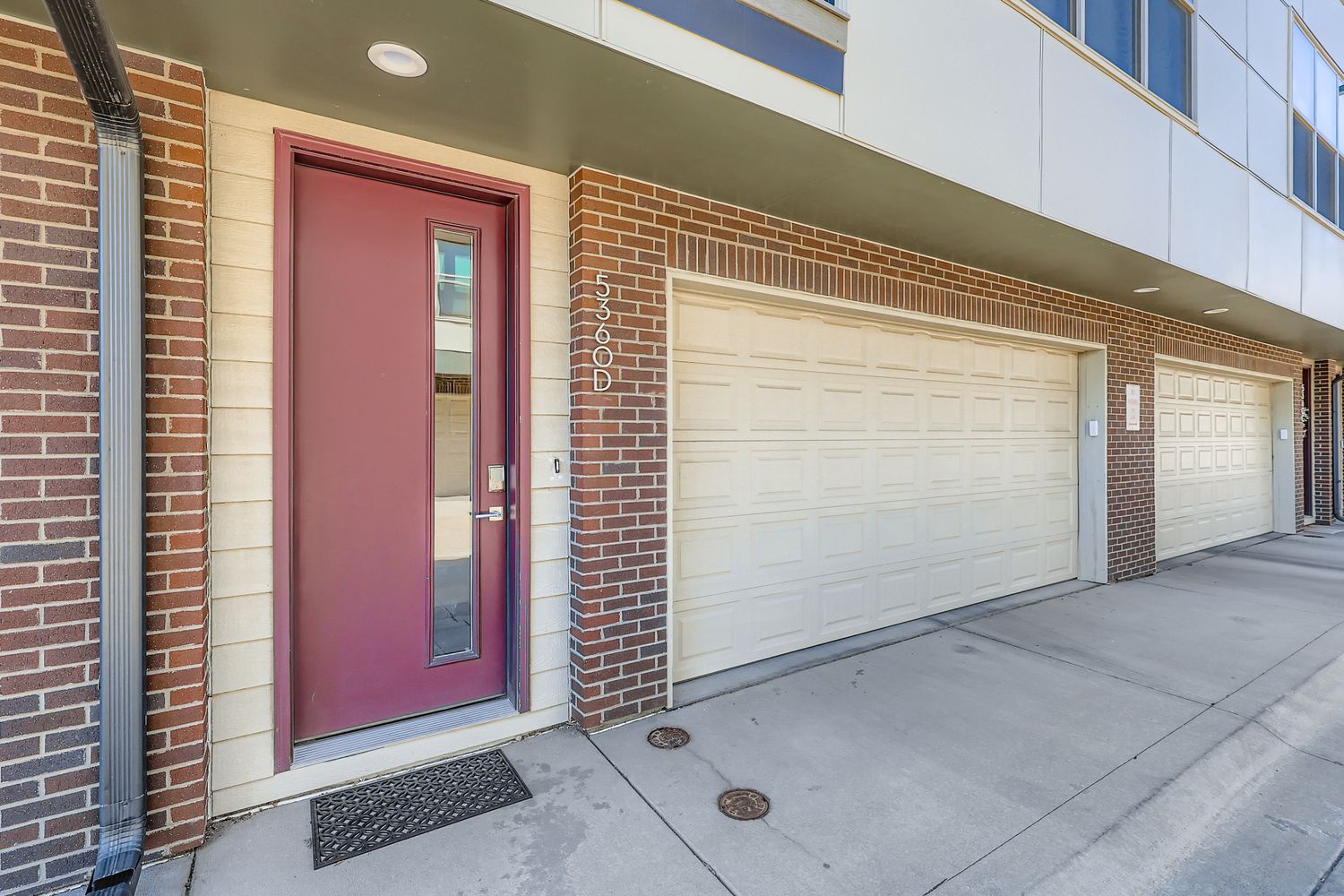Modern brick townhome entrance with convenient garage access for secure parking and easy arrival.