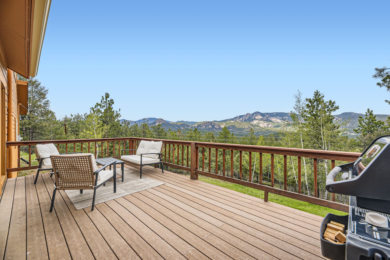 Spacious deck with mountain vistas, outdoor seating, and BBQ grill for memorable meals with stunning natural scenery.