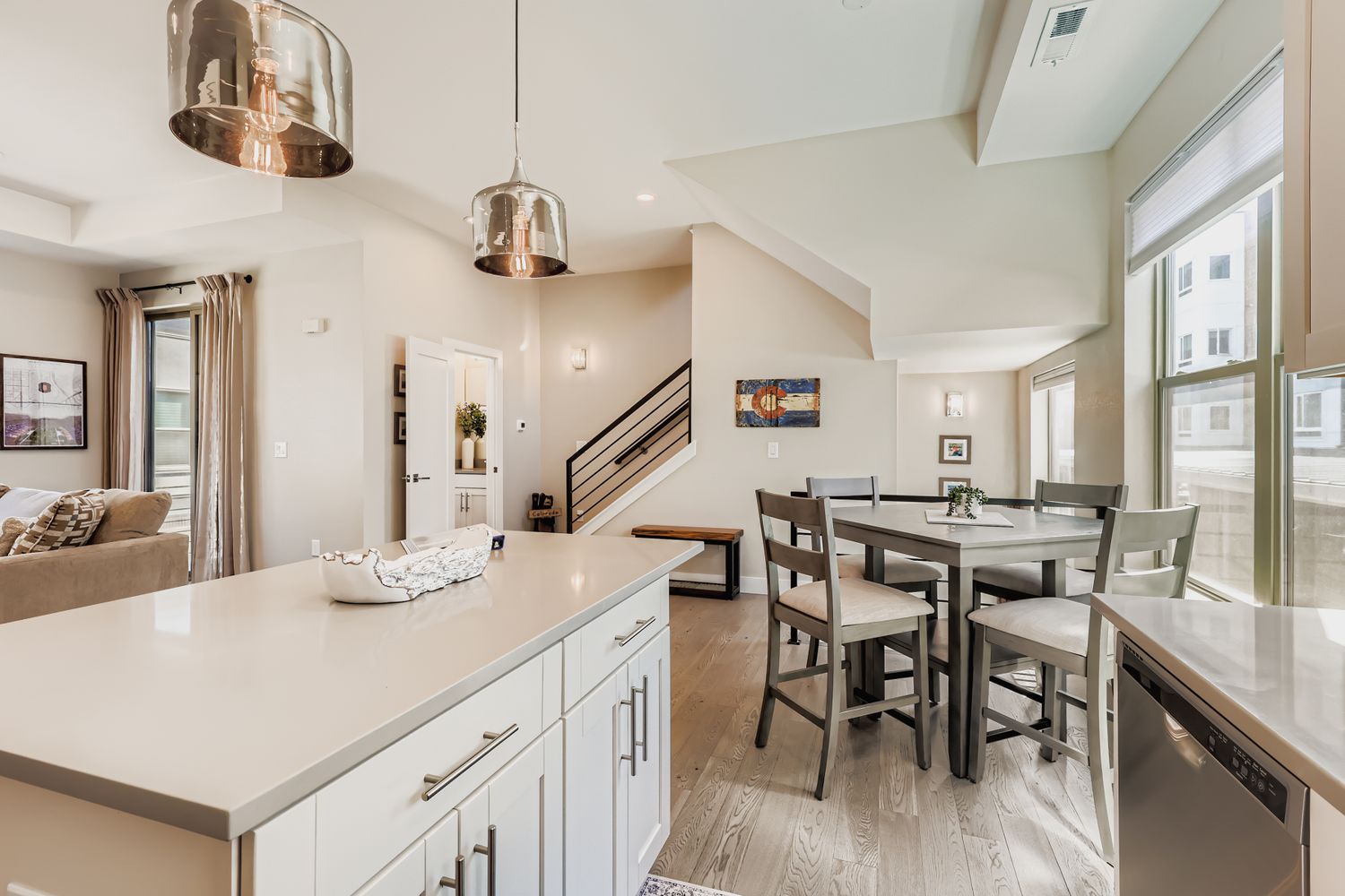 Your modern kitchen island flows seamlessly into the dining space, where stylish pendant lights create perfect ambiance for memorable meals together.