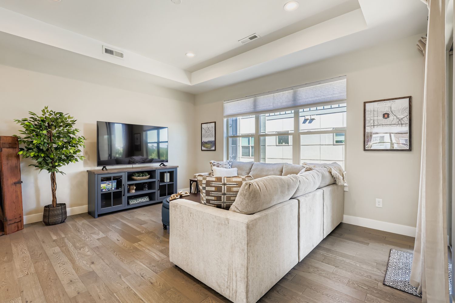 Relax in your bright living room with plush sectional seating, large TV, and modern comfort for perfect vacation evenings.