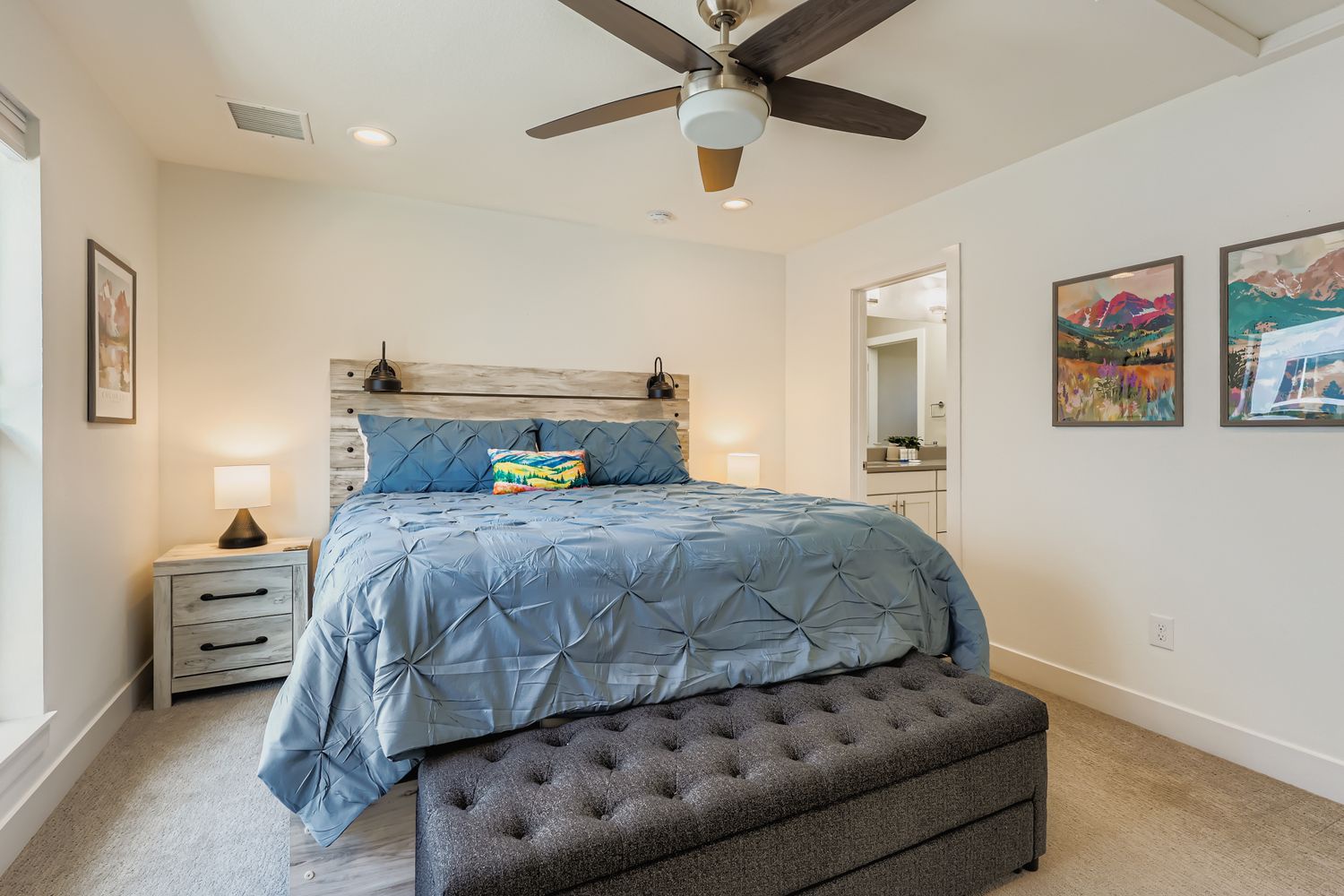 Drift off to sleep beneath gentle ceiling fan breezes in your serene bedroom sanctuary with coastal charm and local artwork.