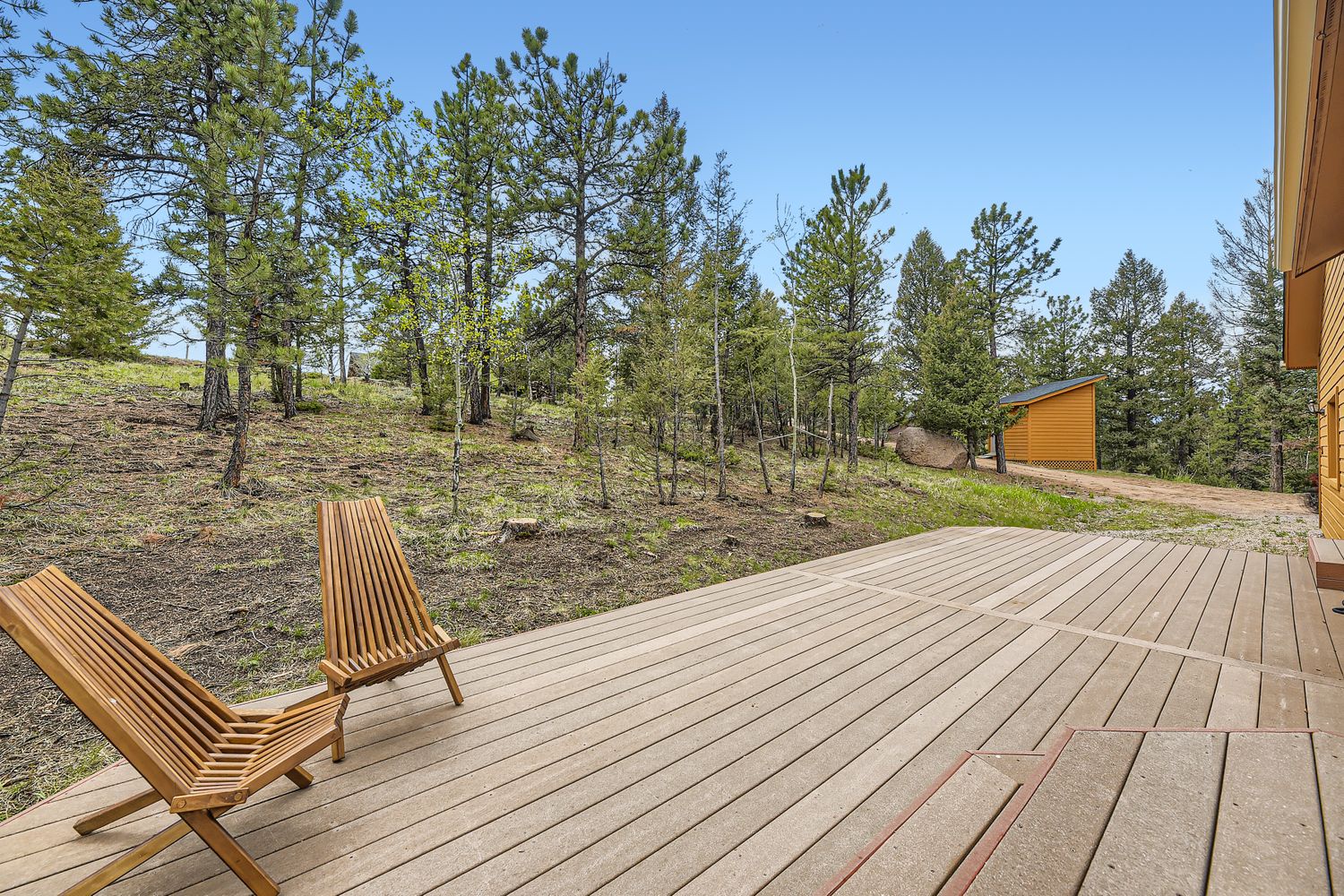 Unwind on your private wooden deck overlooking peaceful forest surroundings, where modern comfort meets pristine wilderness.