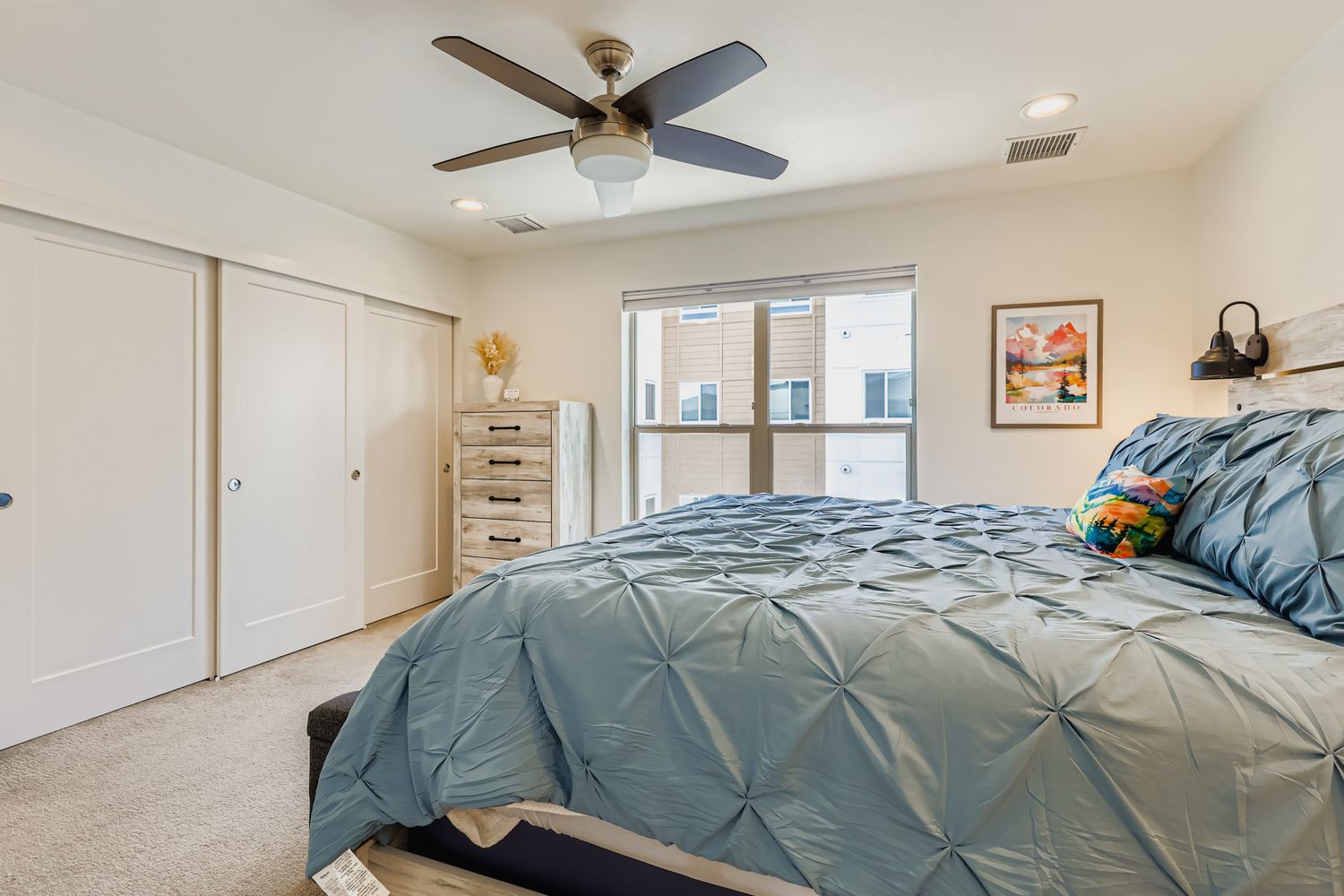 Drift off to sleep in your serene bedroom with plush bedding, gentle ceiling fan breeze, and abundant natural light streaming through large windows.
