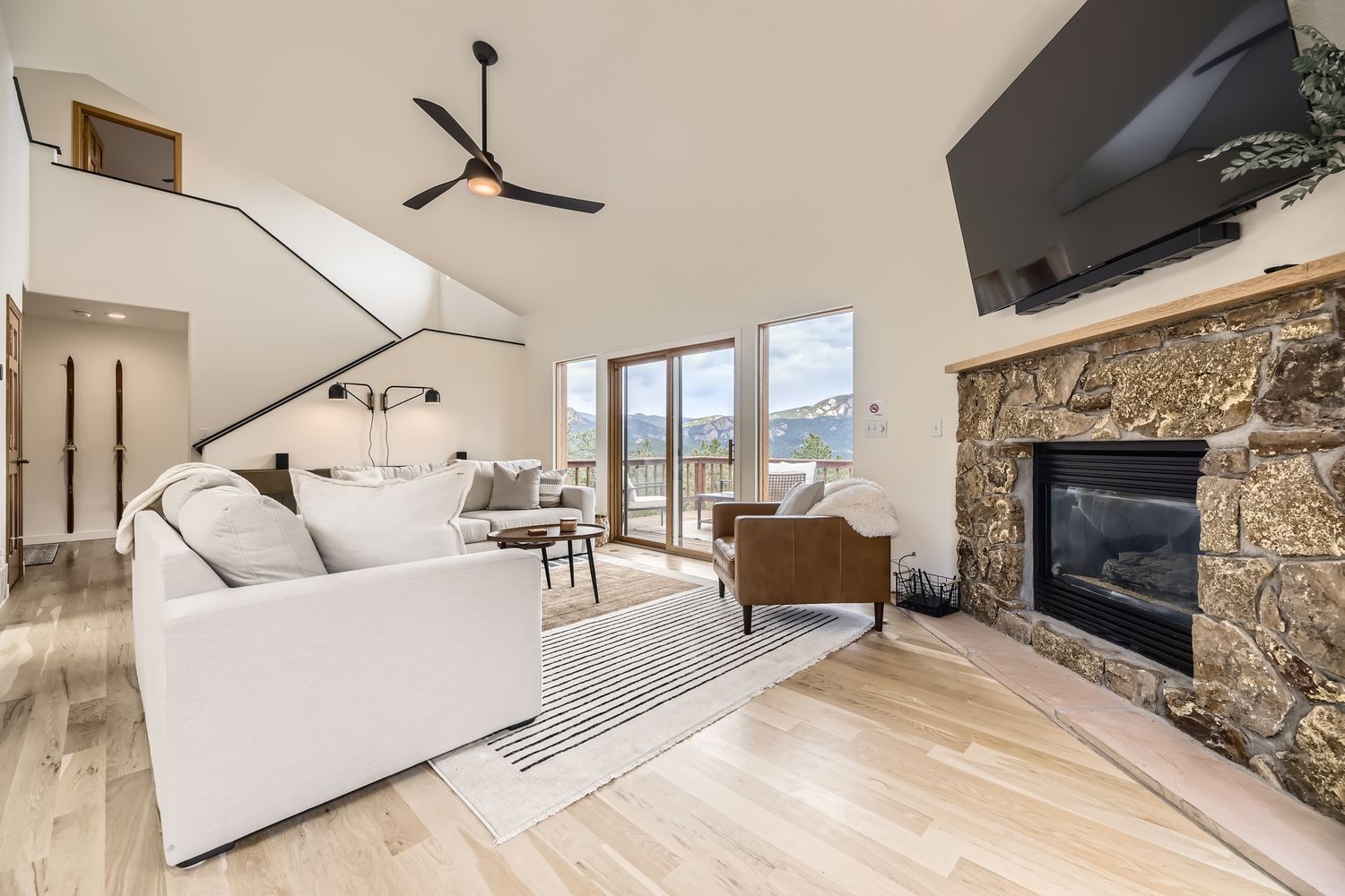 Relax in your bright living room with cozy fireplace and stunning mountain views through expansive windows.