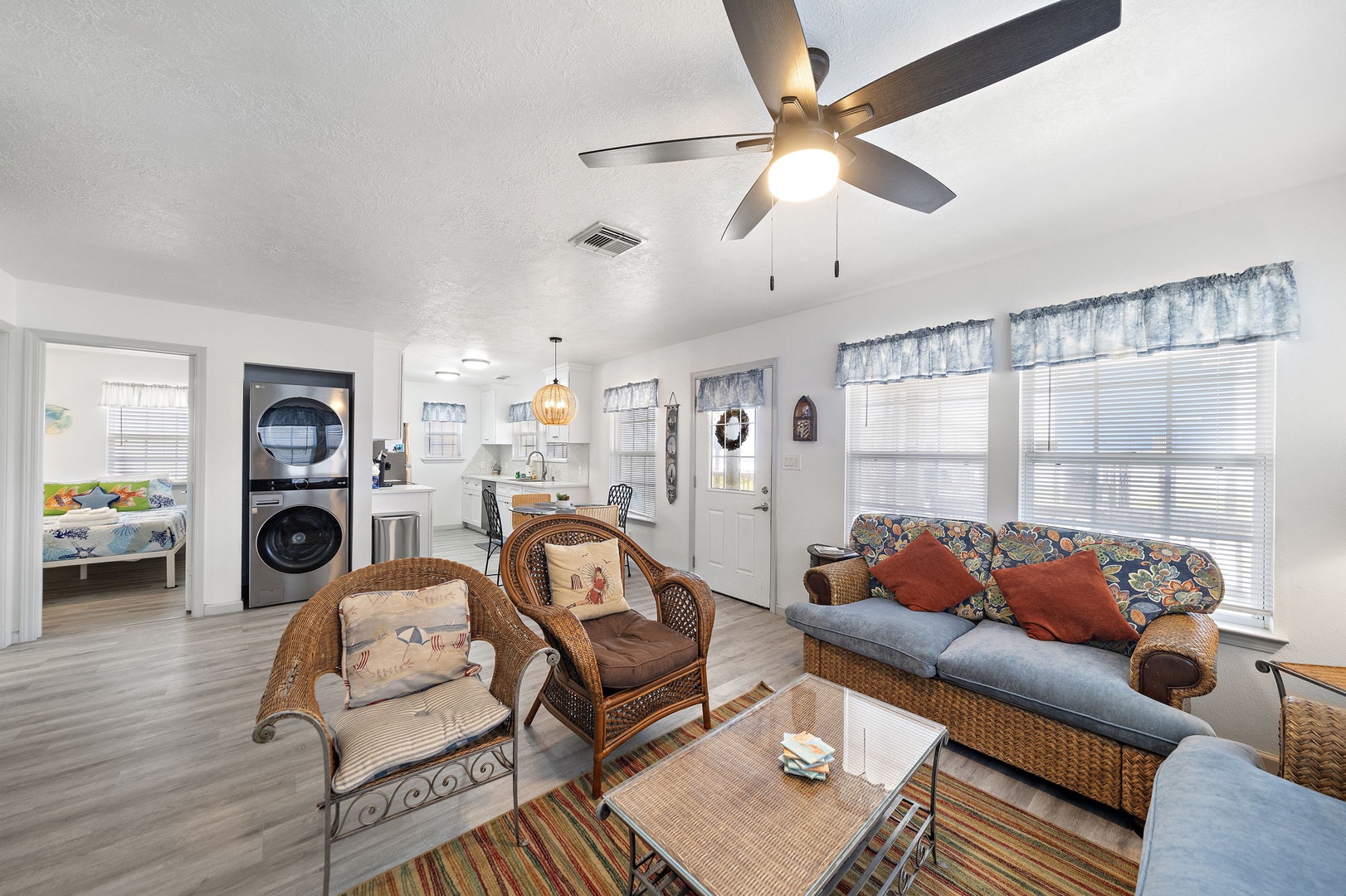 Relax in your bright, airy living space with coastal-inspired wicker furniture and colorful accents. The open layout connects you to a fully equipped kitchen, while your private washer/dryer adds convenience to your stay.