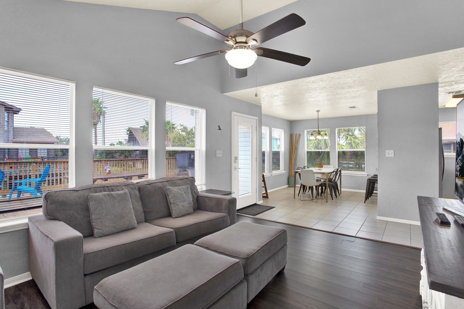 Relax in your open-concept living space featuring a comfy sofa, stylish ceiling fan, and bright windows that fill the room with natural light. Step into the dining area for shared meals or unwind on the covered patio just beyond the front door.