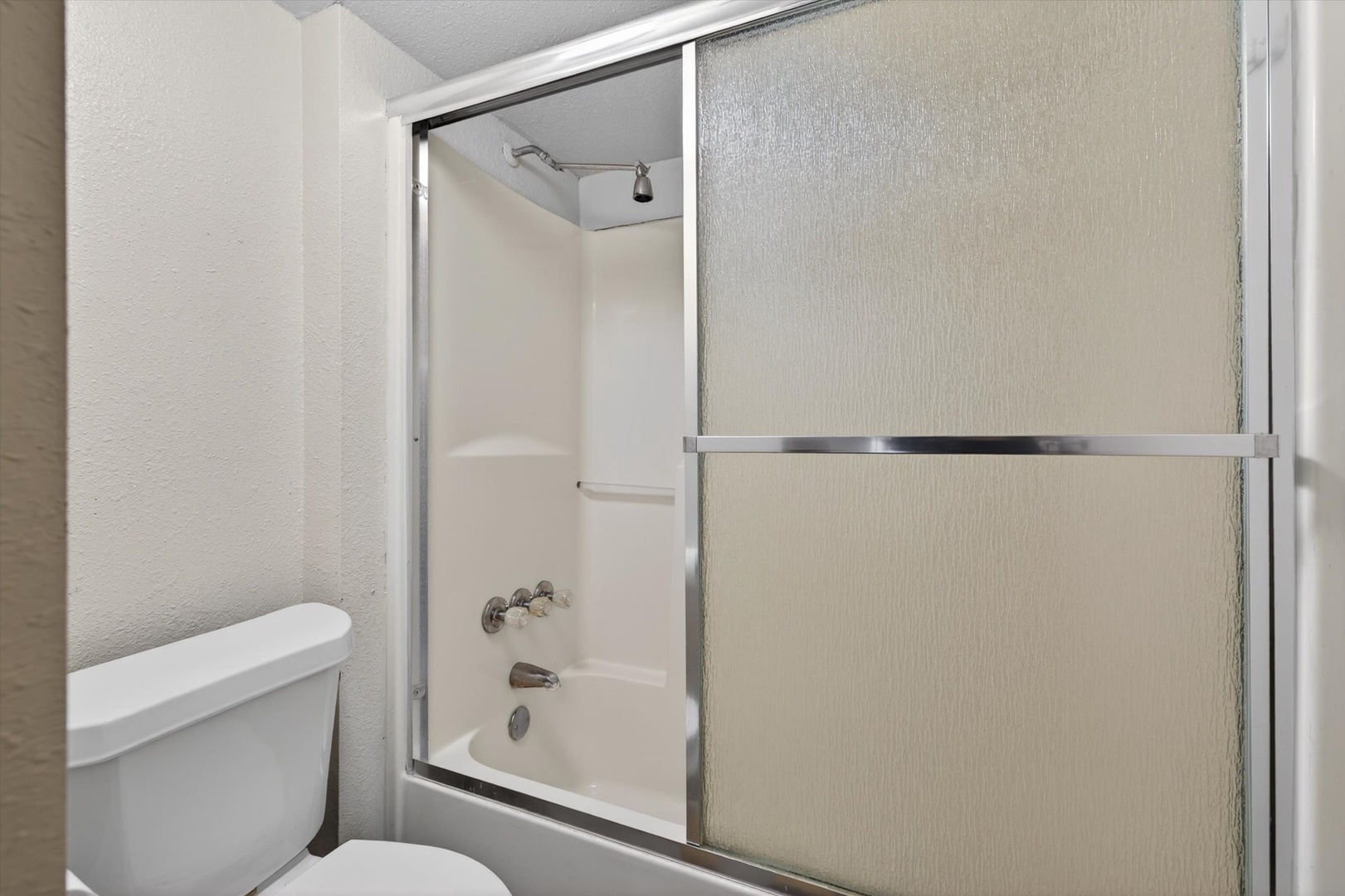Bathroom with glass-door shower and tub essentials.