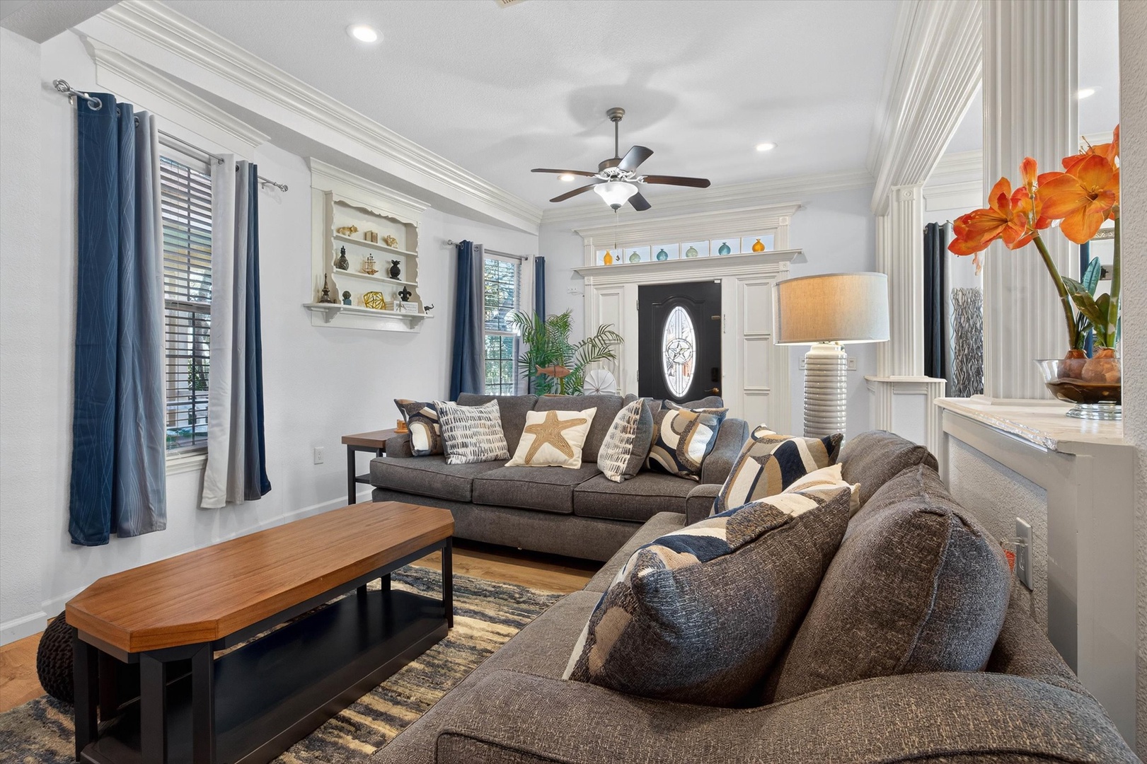 Sink into plush seating surrounded by elegant details and natural light streaming through navy-draped windows in your stylish living space.
