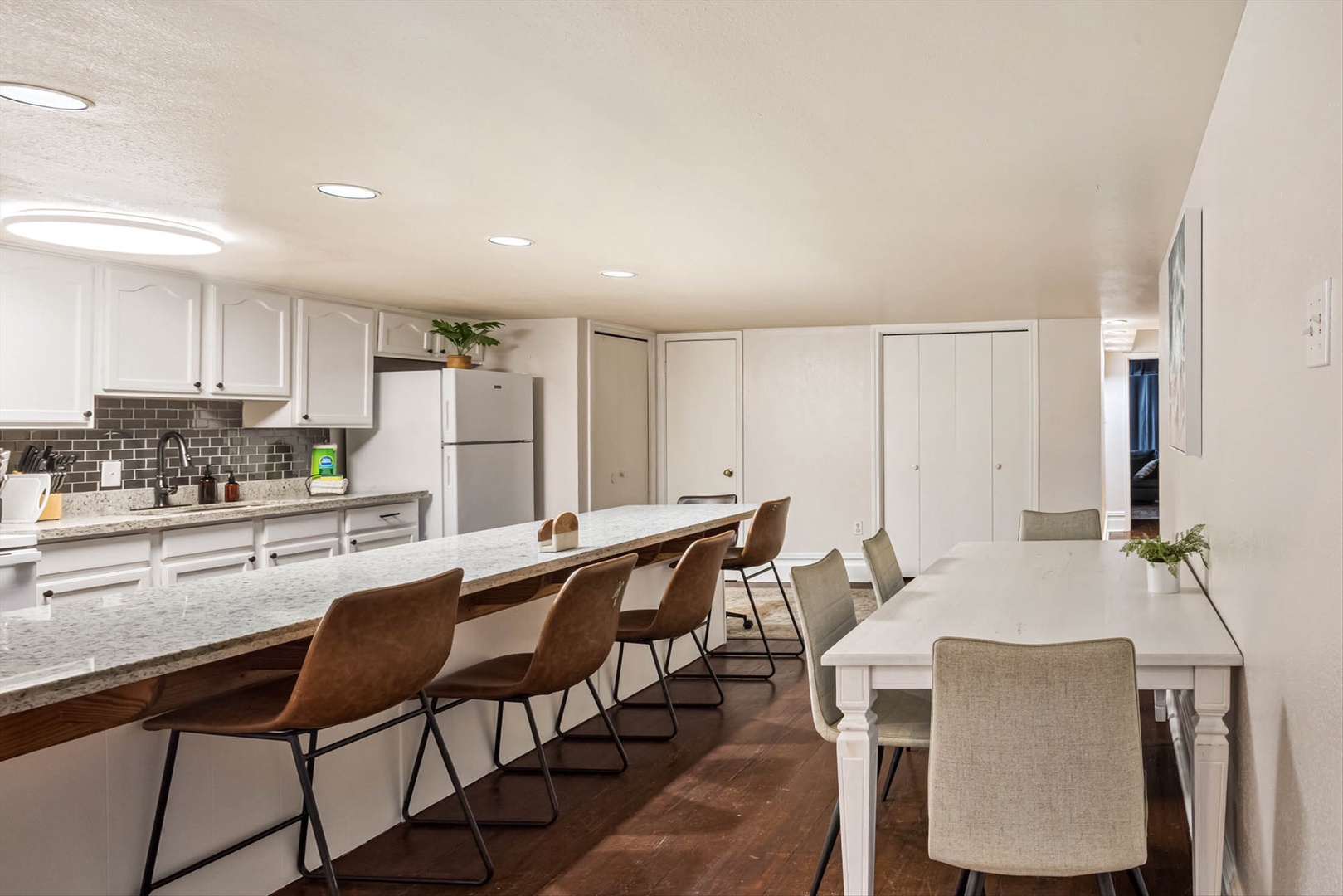 Kitchen with granite counters, appliances, and group seating.