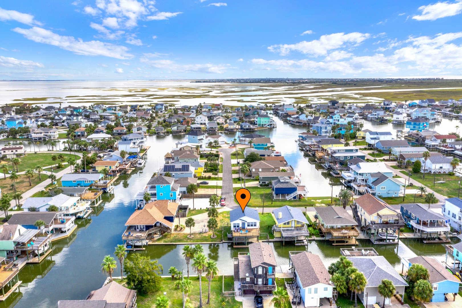 Aerial view of Jamaica Beach with canal access, showcasing colorful coastal homes nestled along tranquil waterways and expansive bay views.