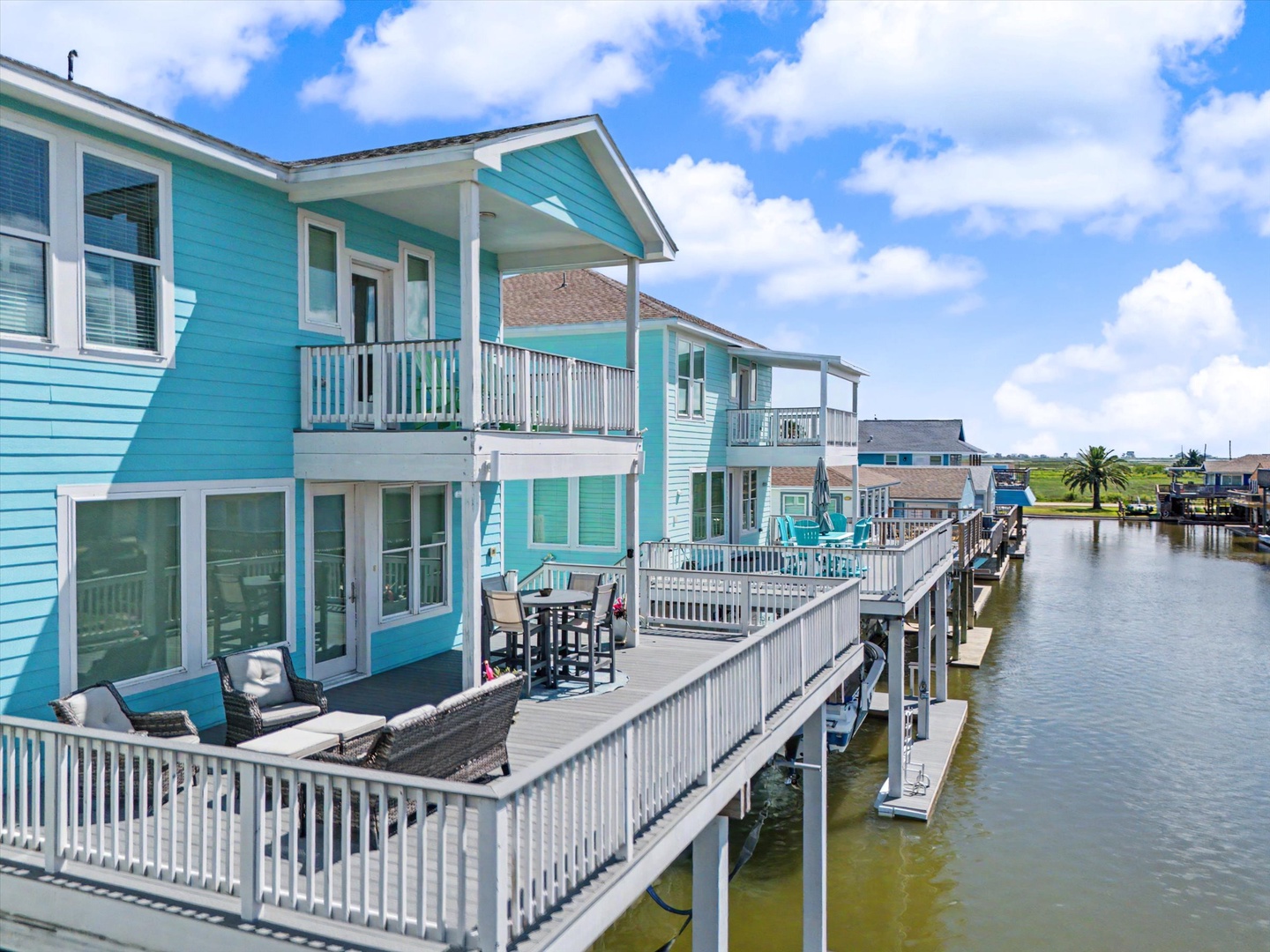 Bright turquoise coastal homes line a peaceful canal.