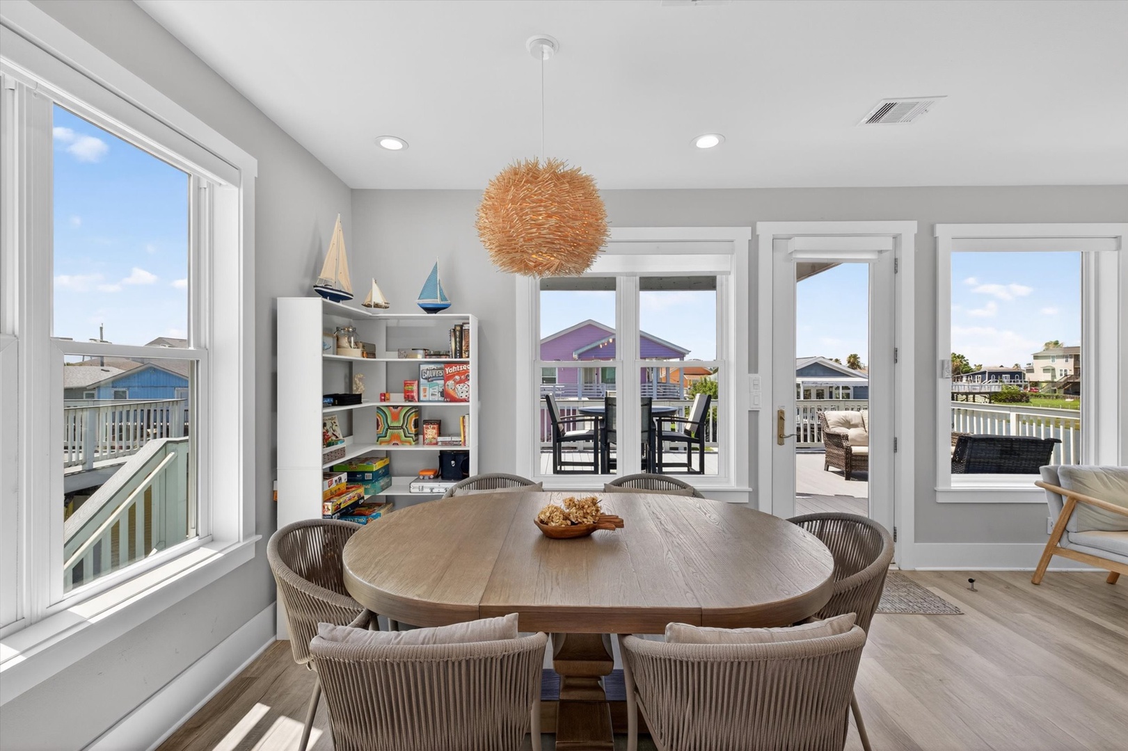 Dining area with balcony, wood table, and bright light.