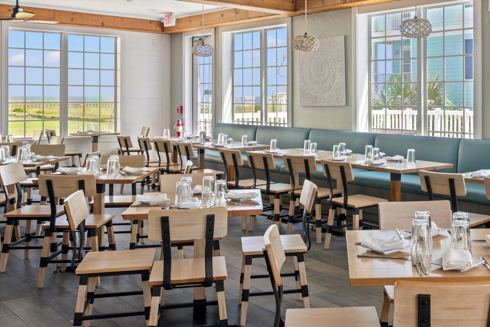 Modern restaurant with coastal views and elegant tables.