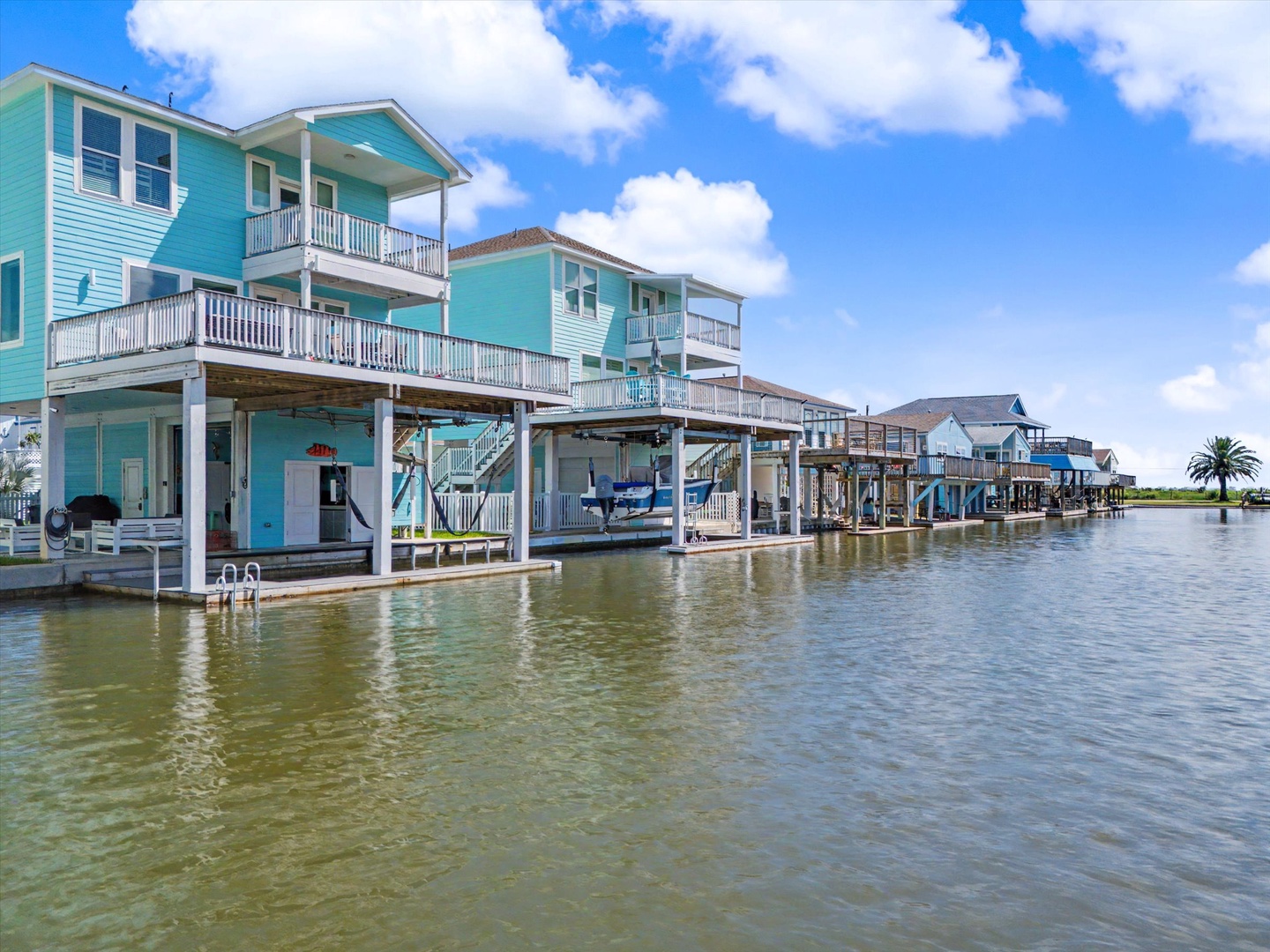Colorful waterfront properties on stilts line a tranquil canal.