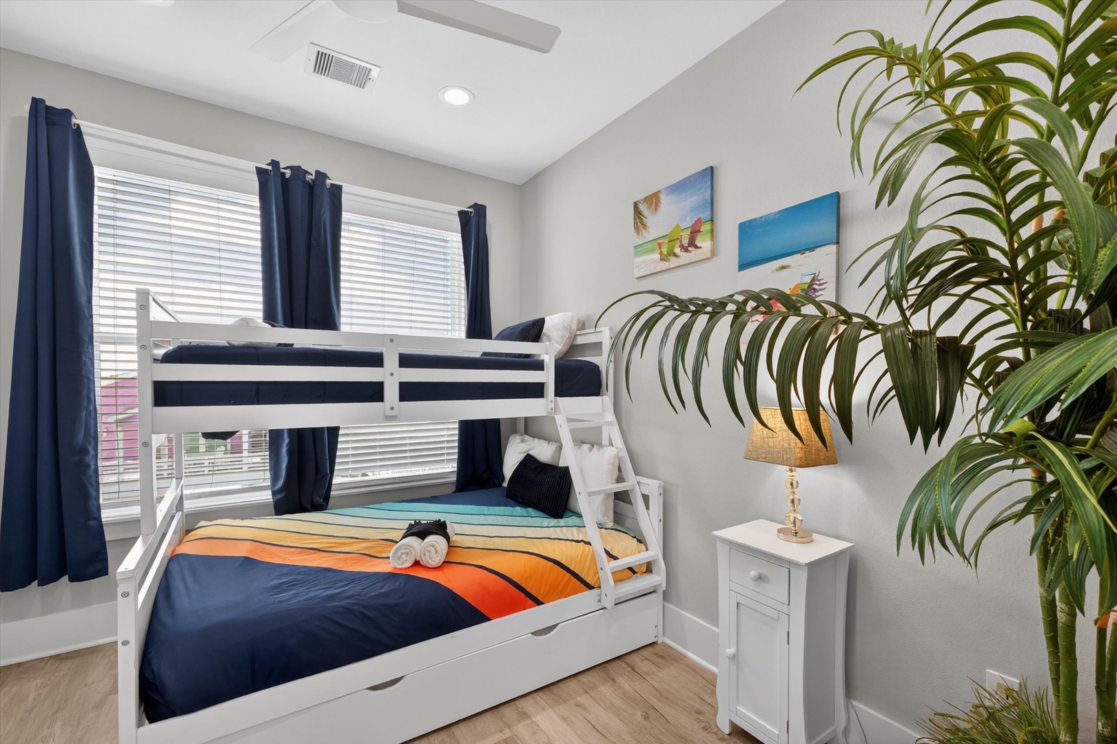 Navy and orange bedding in a coastal bunk retreat.