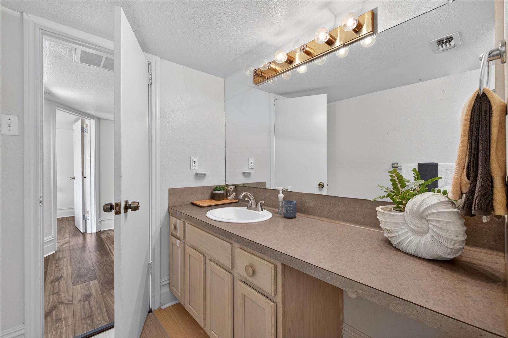Fresh, bright bathroom with towels and vanity lighting.