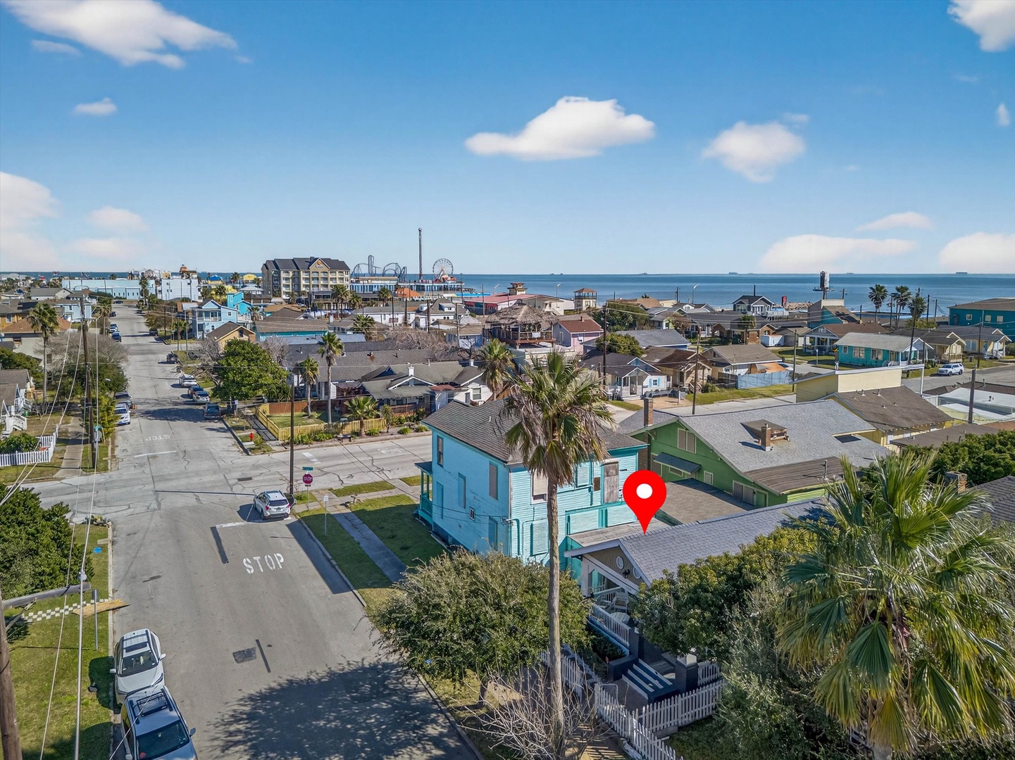 Aerial view of charming coastal neighborhood with colorful beach homes just steps from the beach and attractions.