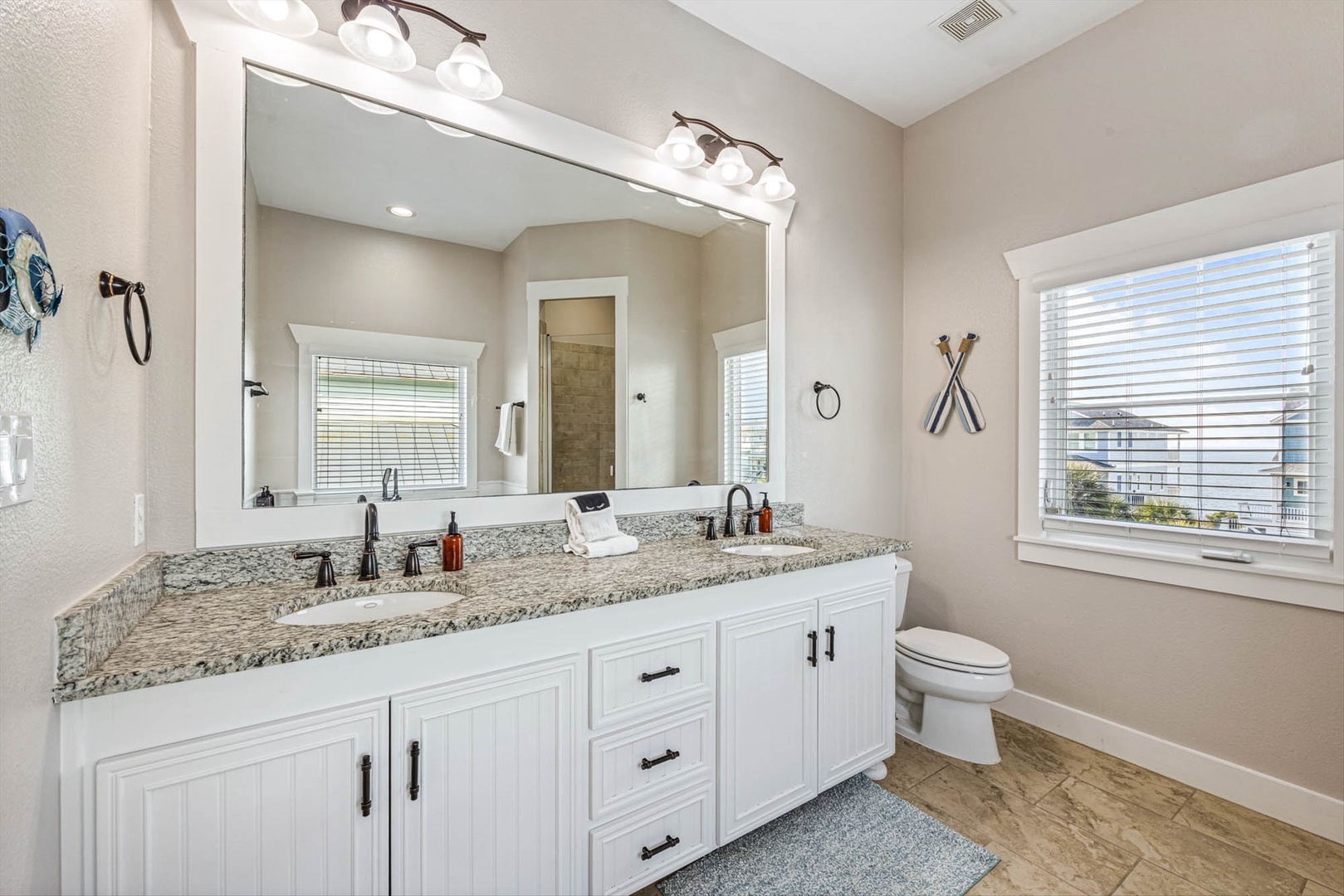 Bright bathroom with dual sinks and granite countertops.