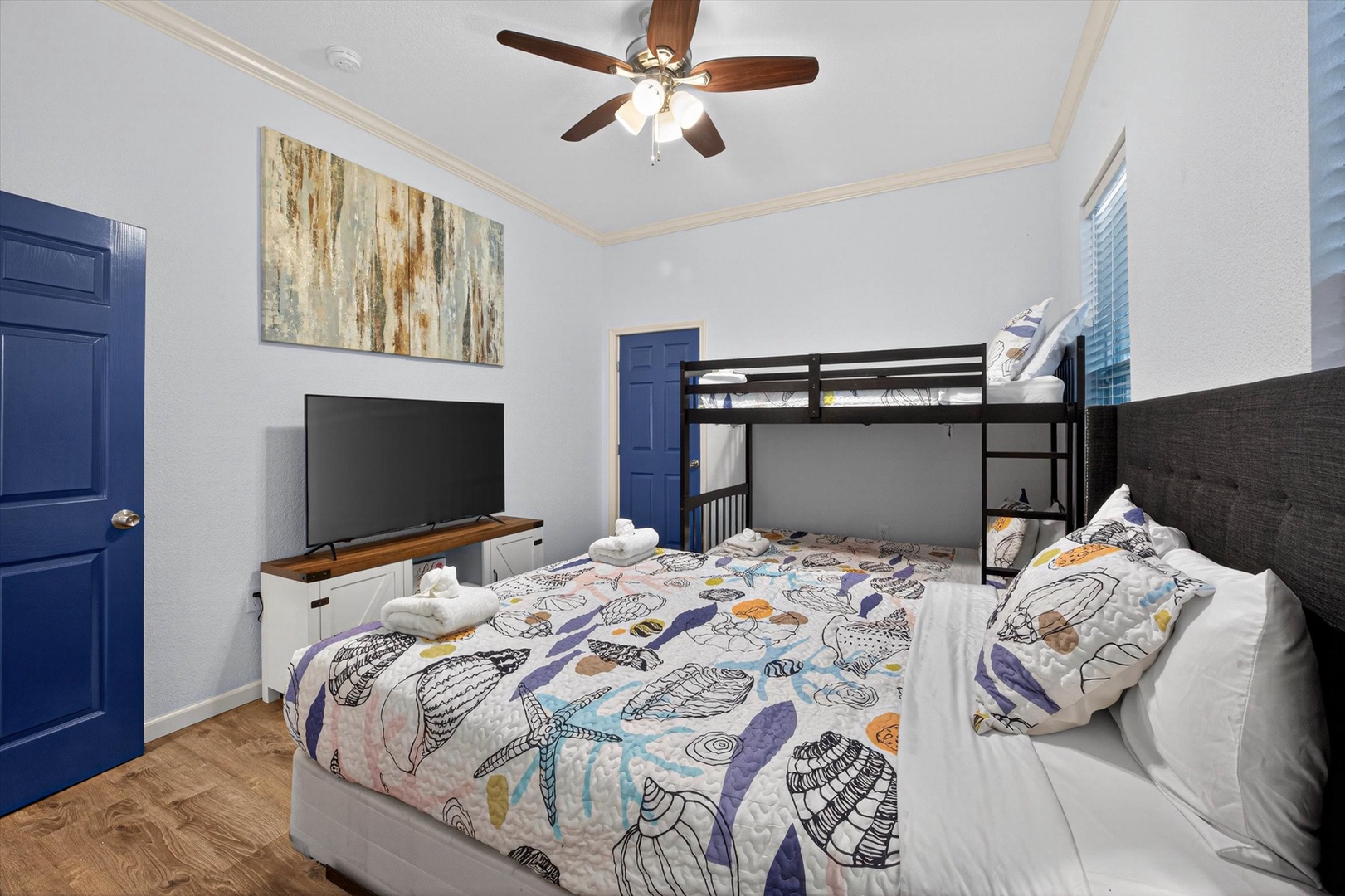 Your family bedroom features a queen bed and twin bunk beds with cozy linens, plus a TV for movie nights together.