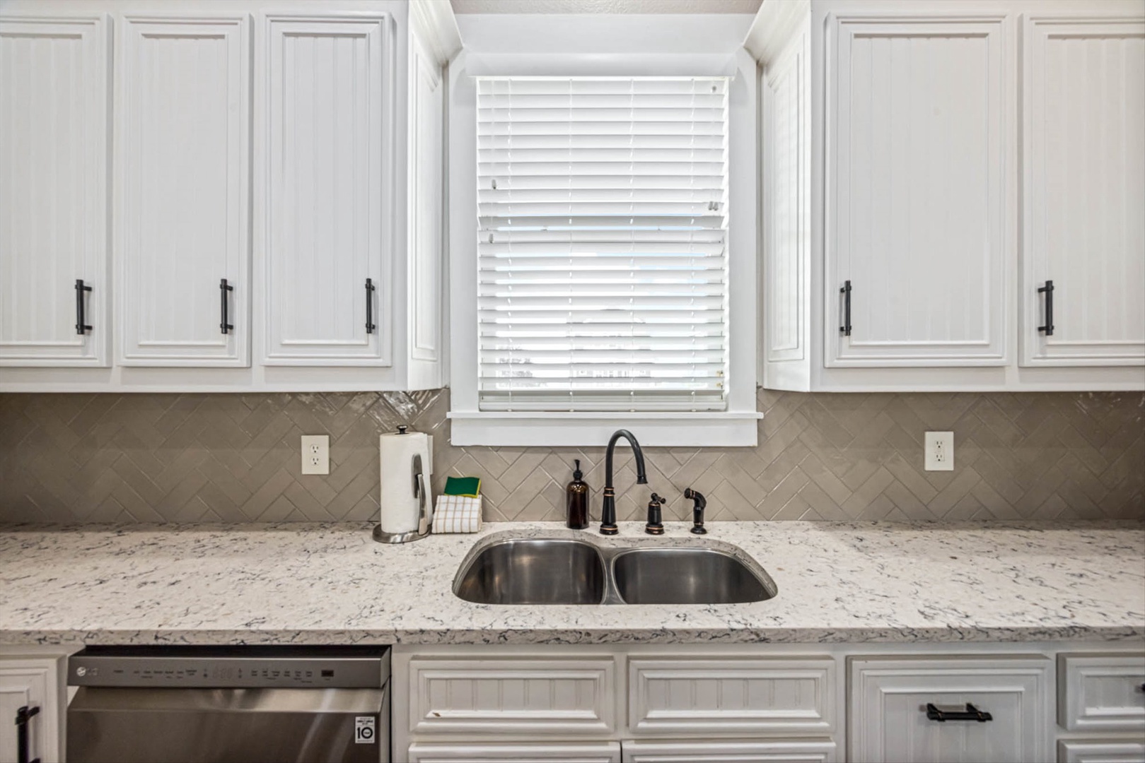 Elegant kitchen with granite, white cabinets, and natural light.