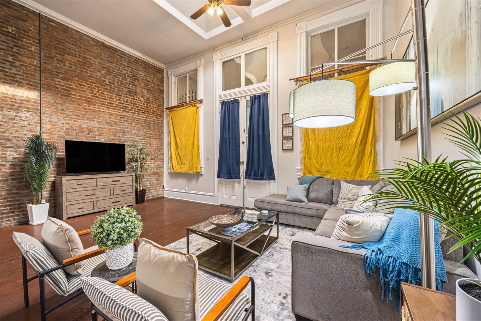 Plush seating with vibrant curtains and exposed brick charm.