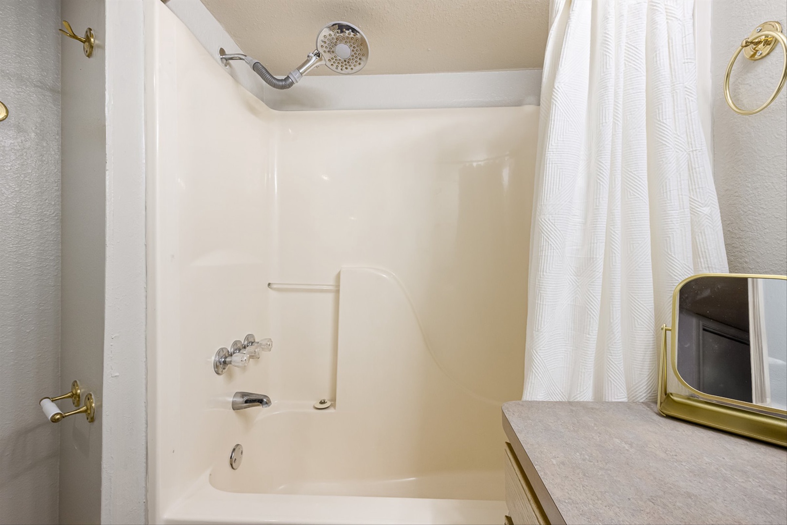 Spotless bathroom with tub-shower, plush towels, and fixtures.