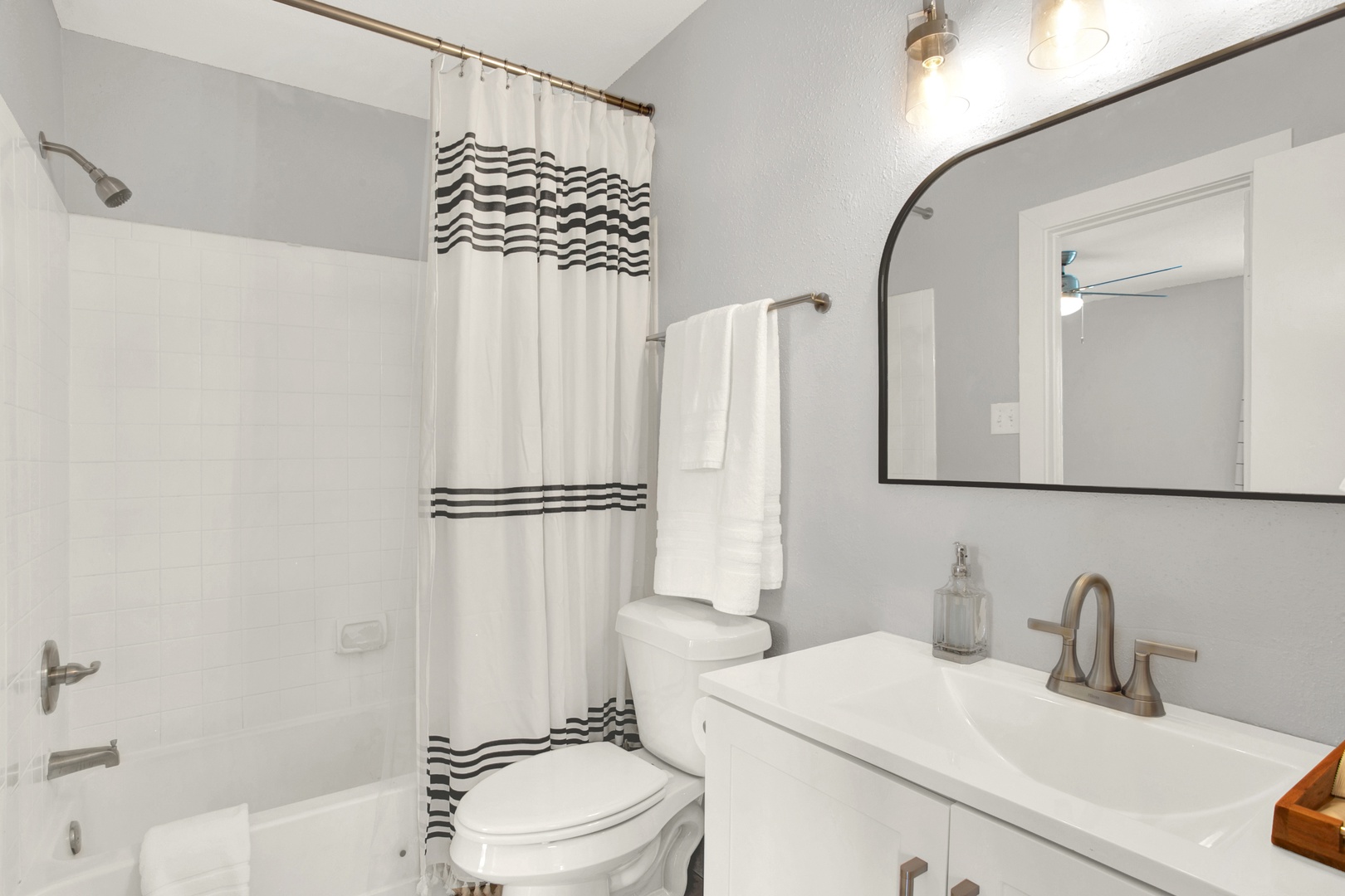 Clean bathroom with tub-shower and fluffy towels