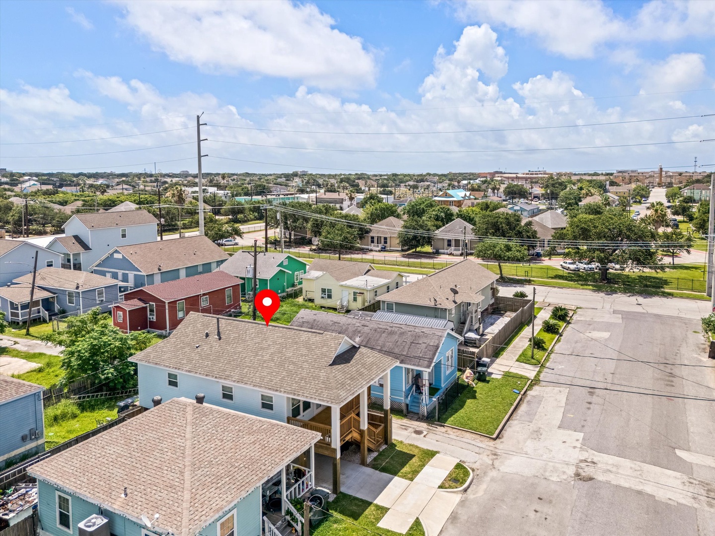 Aerial view of neighborhood with homes and green spaces.