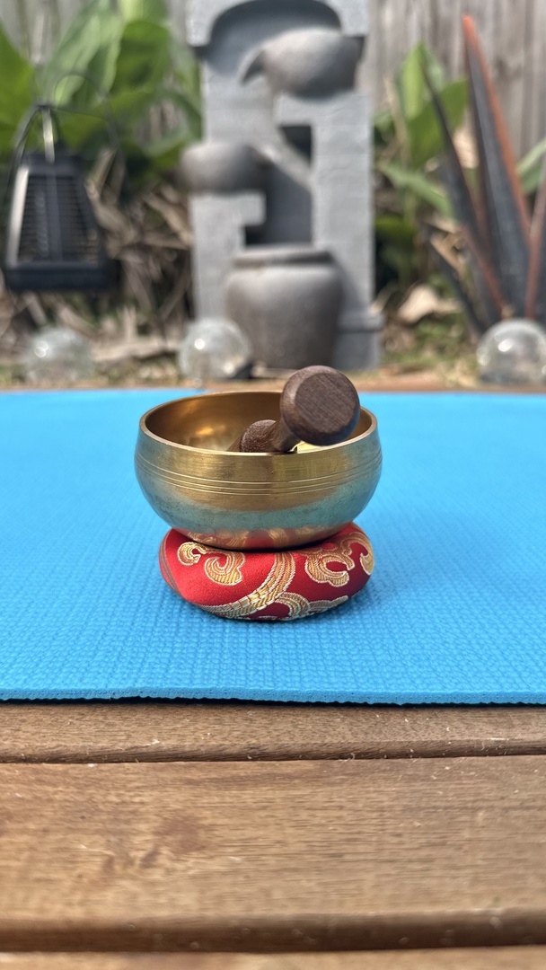 A peaceful meditation space awaits you, complete with singing bowl and serene garden backdrop—your personal retreat for mindful moments.