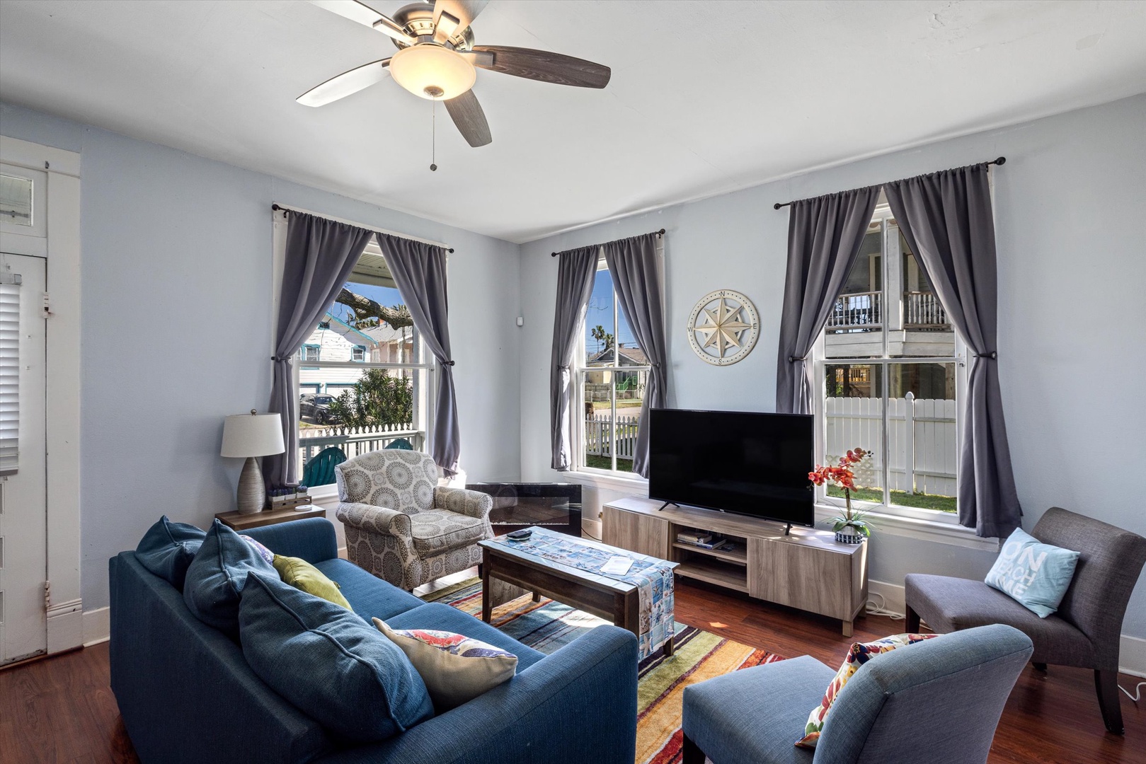 Relax in your spacious living room with comfortable seating, entertainment center, and natural light streaming through multiple windows.