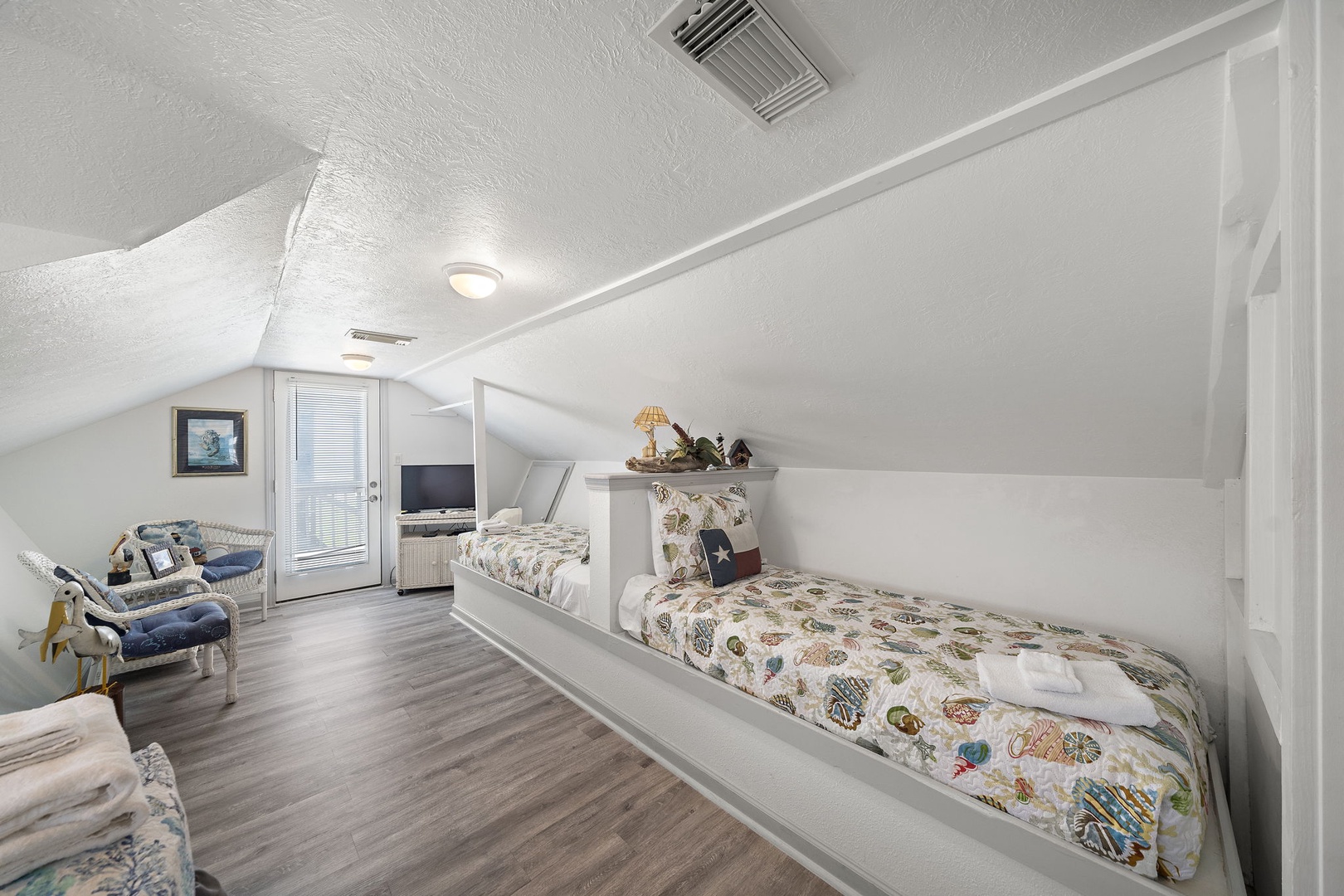 Drift off to peaceful dreams in this charming attic bedroom where cozy built-in beds create your own private hideaway under the eaves, complete with soft lighting and serene ocean views.