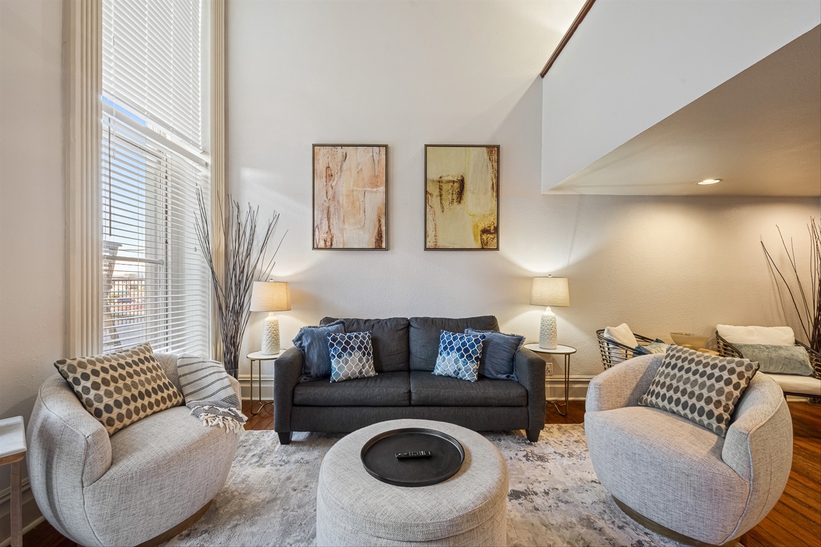Stylish living room with plush seating with queen size sofa bed and high ceilings.