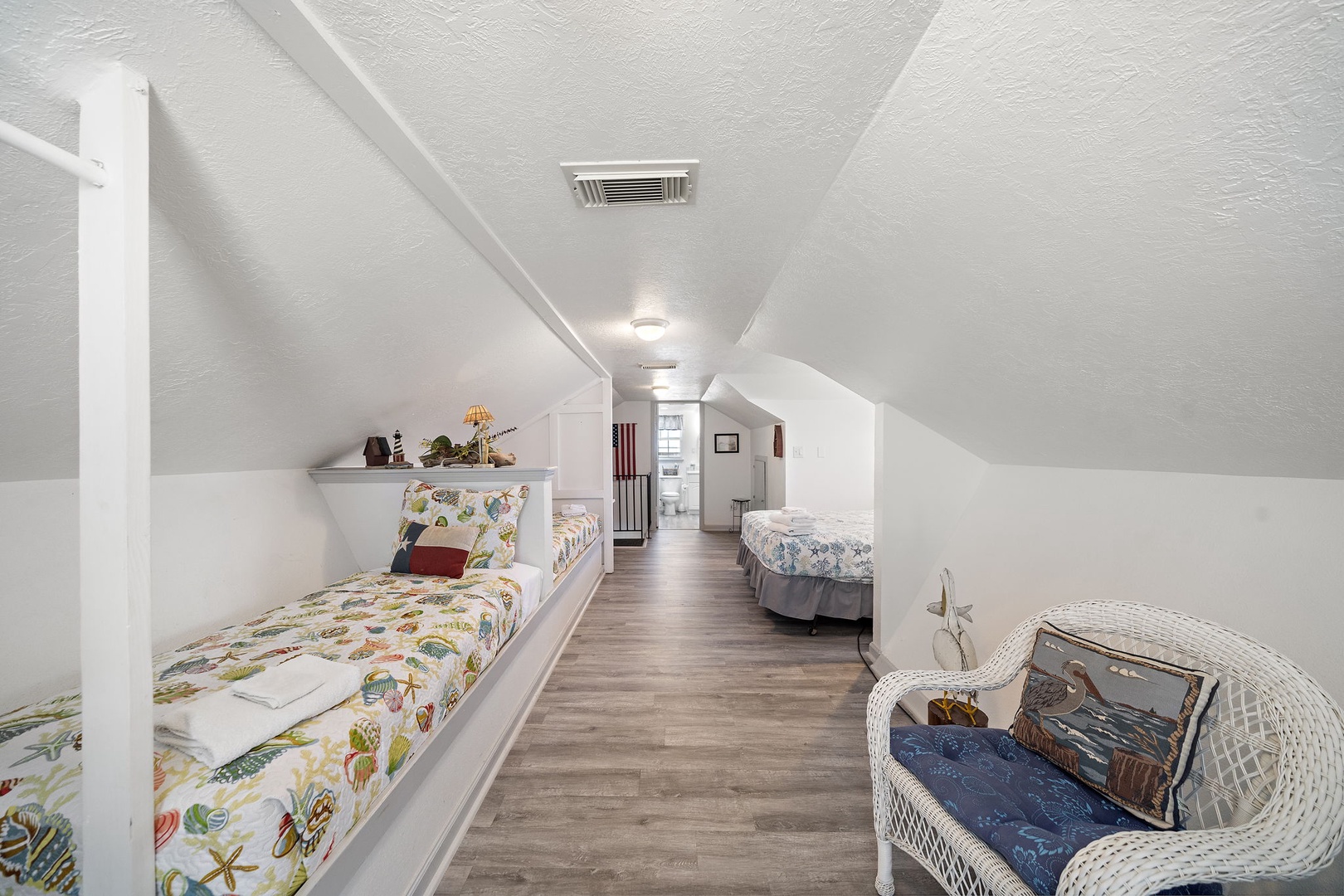 Your cozy attic retreat awaits with comfortable beds tucked under charming sloped ceilings. Perfect for kids or extra guests, this bright space feels like a secret hideaway where you can unwind after beach adventures.