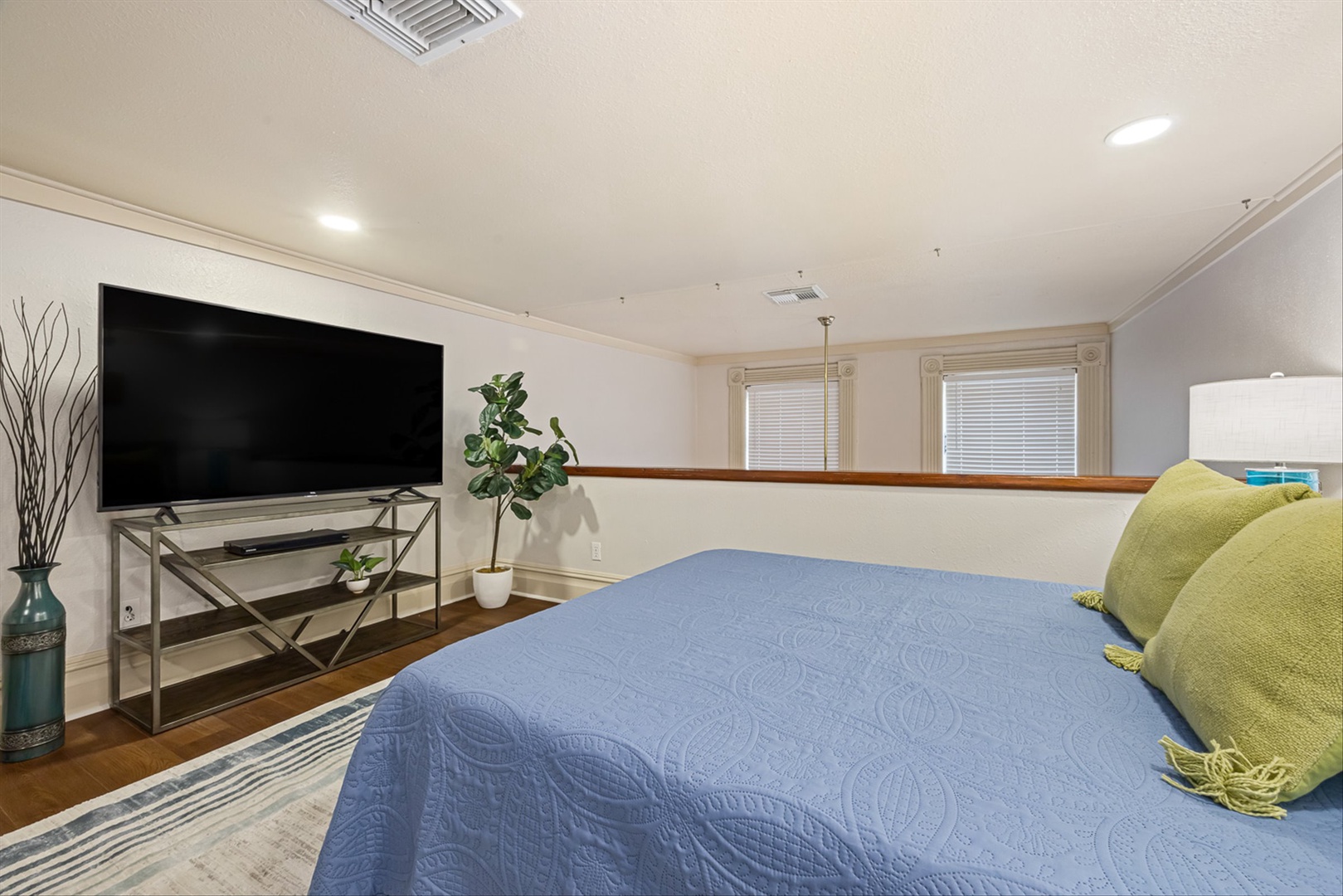 Comfortable bedroom with TV and calming blue linens.