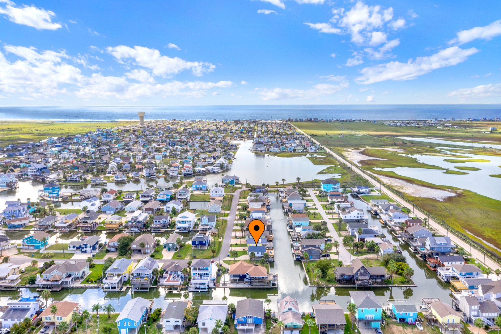 Aerial view of a waterfront community where canals meet the Gulf Coast, offering access to both coastal living and the open sea.