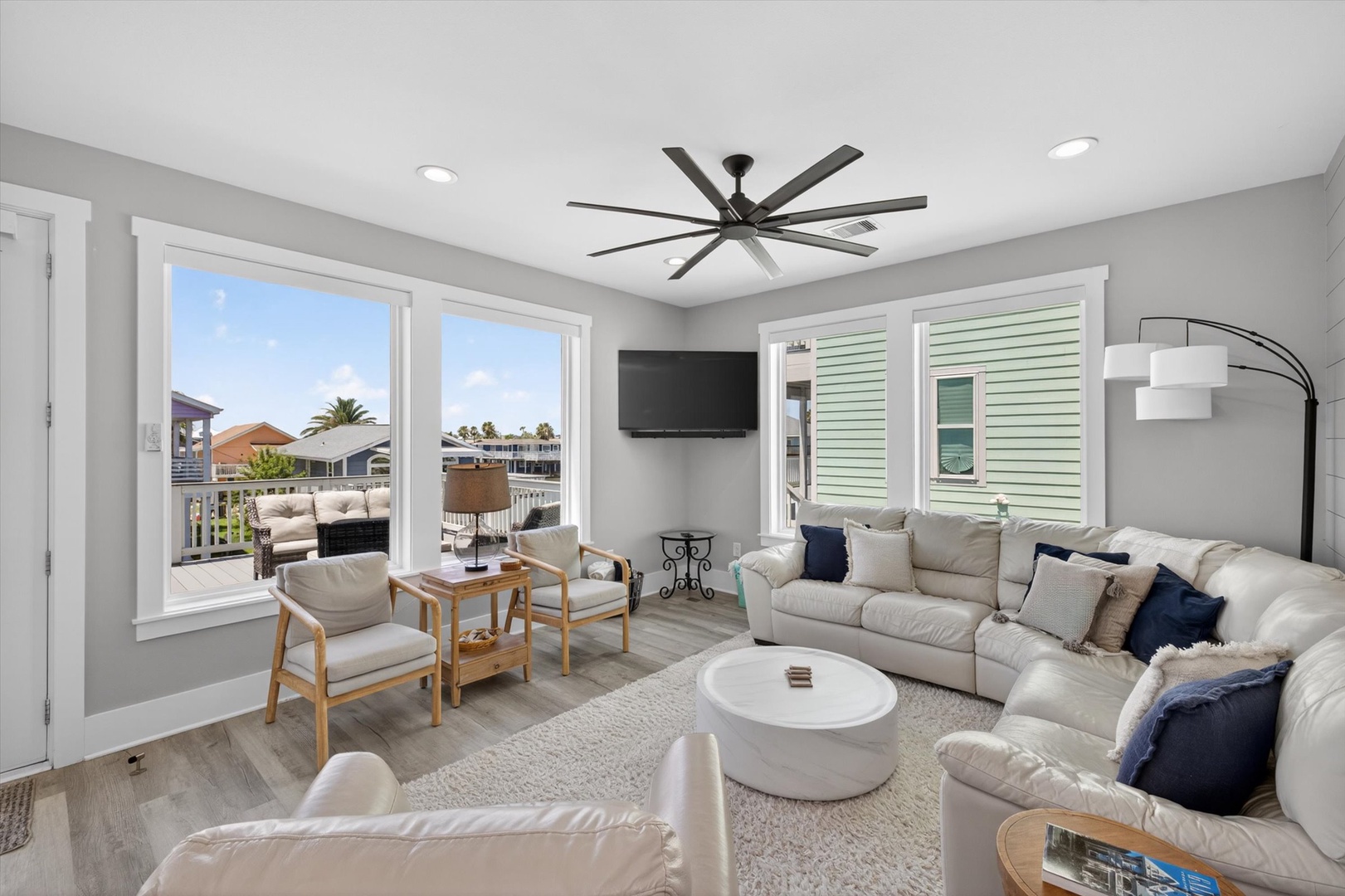 Modern living space with TV, ceiling fan, and ocean views