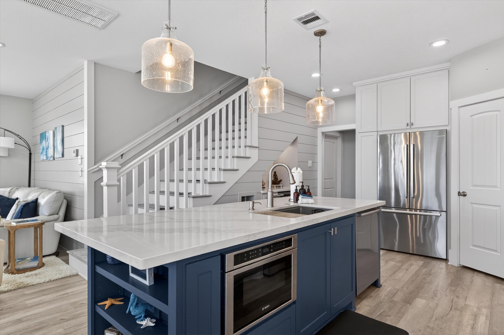 Modern kitchen with stainless appliances and pendant lights.