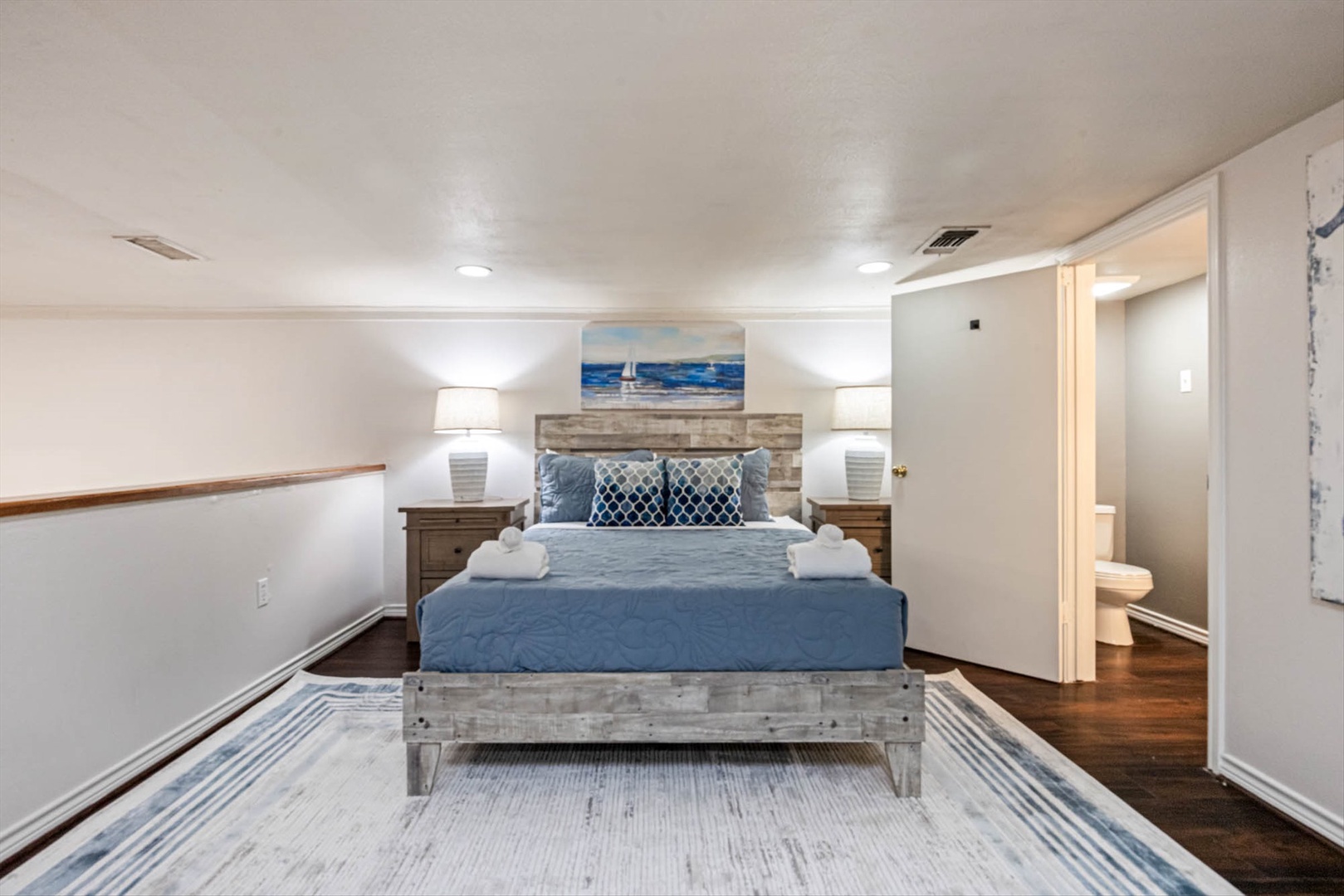 Unwind in a coastal bedroom with rustic headboard and soft linens.