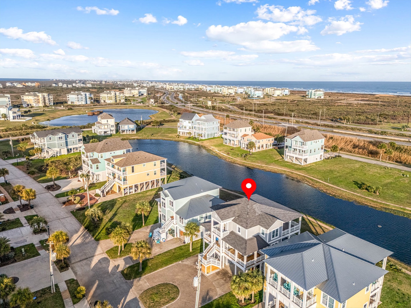 Aerial view of waterfront homes with canal and beach access.
