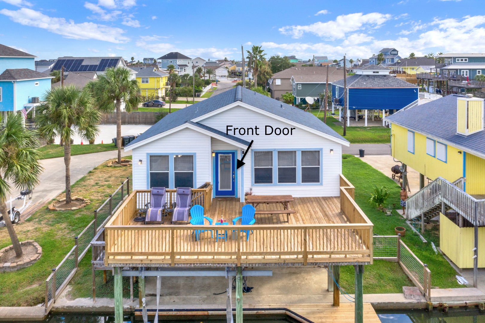 This charming coastal property sits in a vibrant waterfront neighborhood surrounded by colorful beach houses and swaying palm trees, offering easy canal access and a welcoming front deck perfect for soaking up the sunshine.