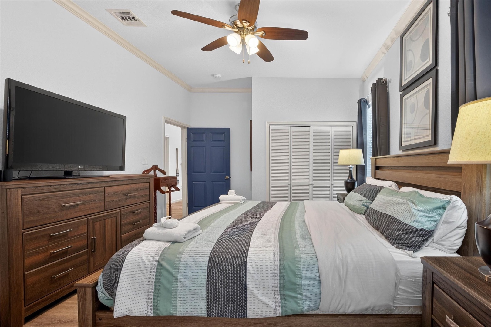 Your comfortable bedroom features a plush bed with soft linens, warm wood furnishings, and a ceiling fan for perfect temperature control.
